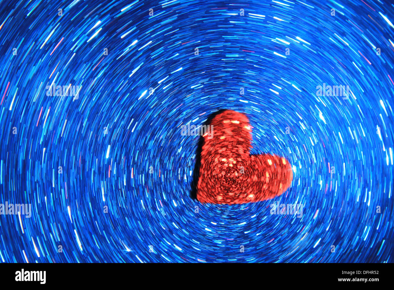 Amore e romanticismo - cuore rosso Swirl attraverso una galassia di blu Foto Stock