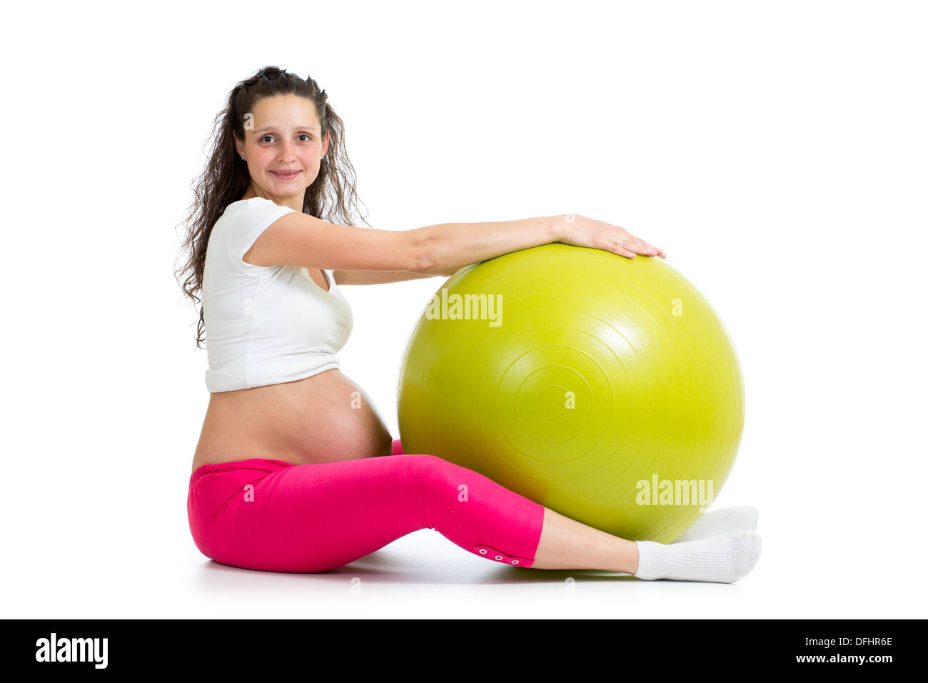 Donna incinta con esercizi di montare la sfera Foto Stock