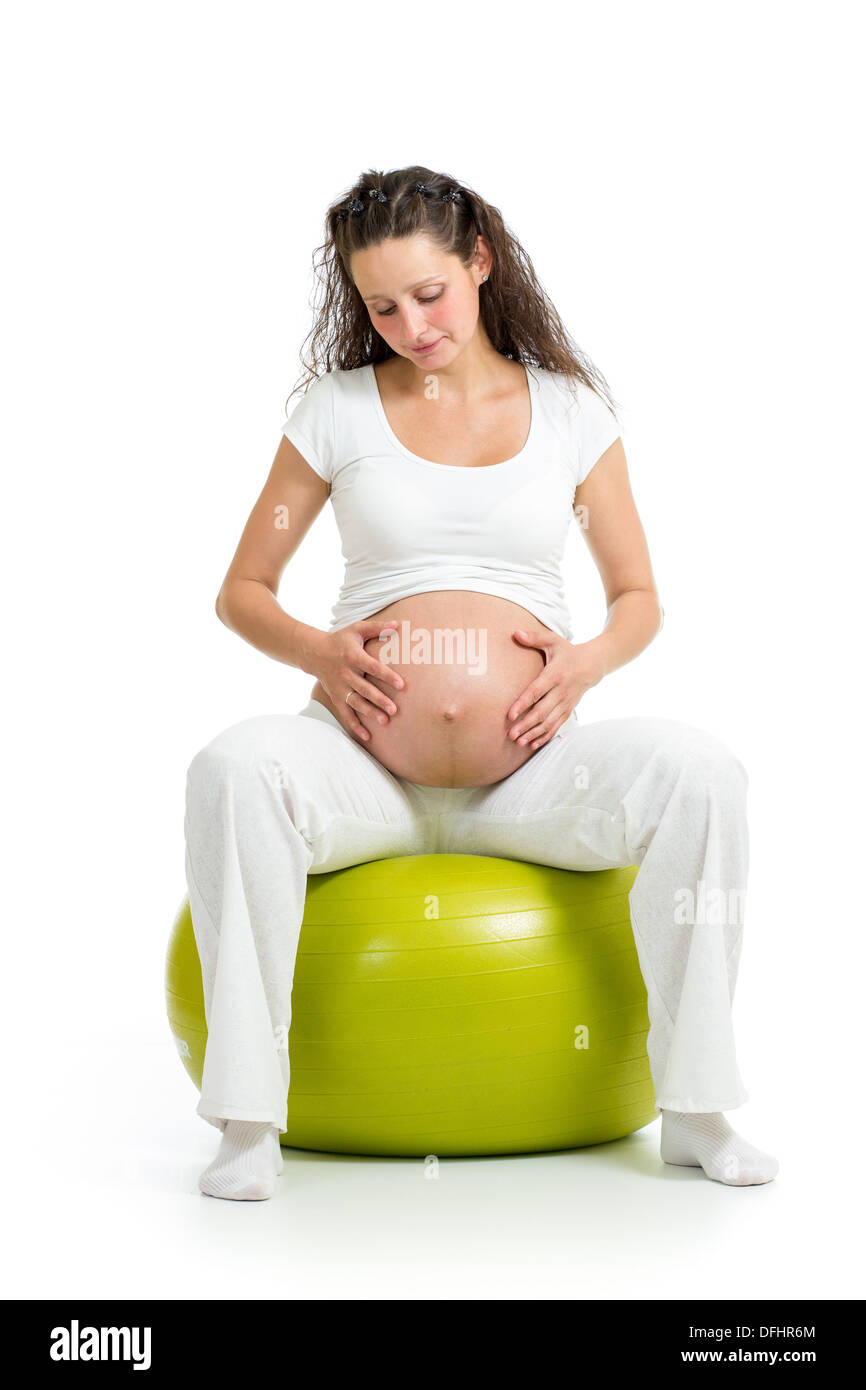 Donna incinta seduta sulla sfera fitness isolato Foto Stock