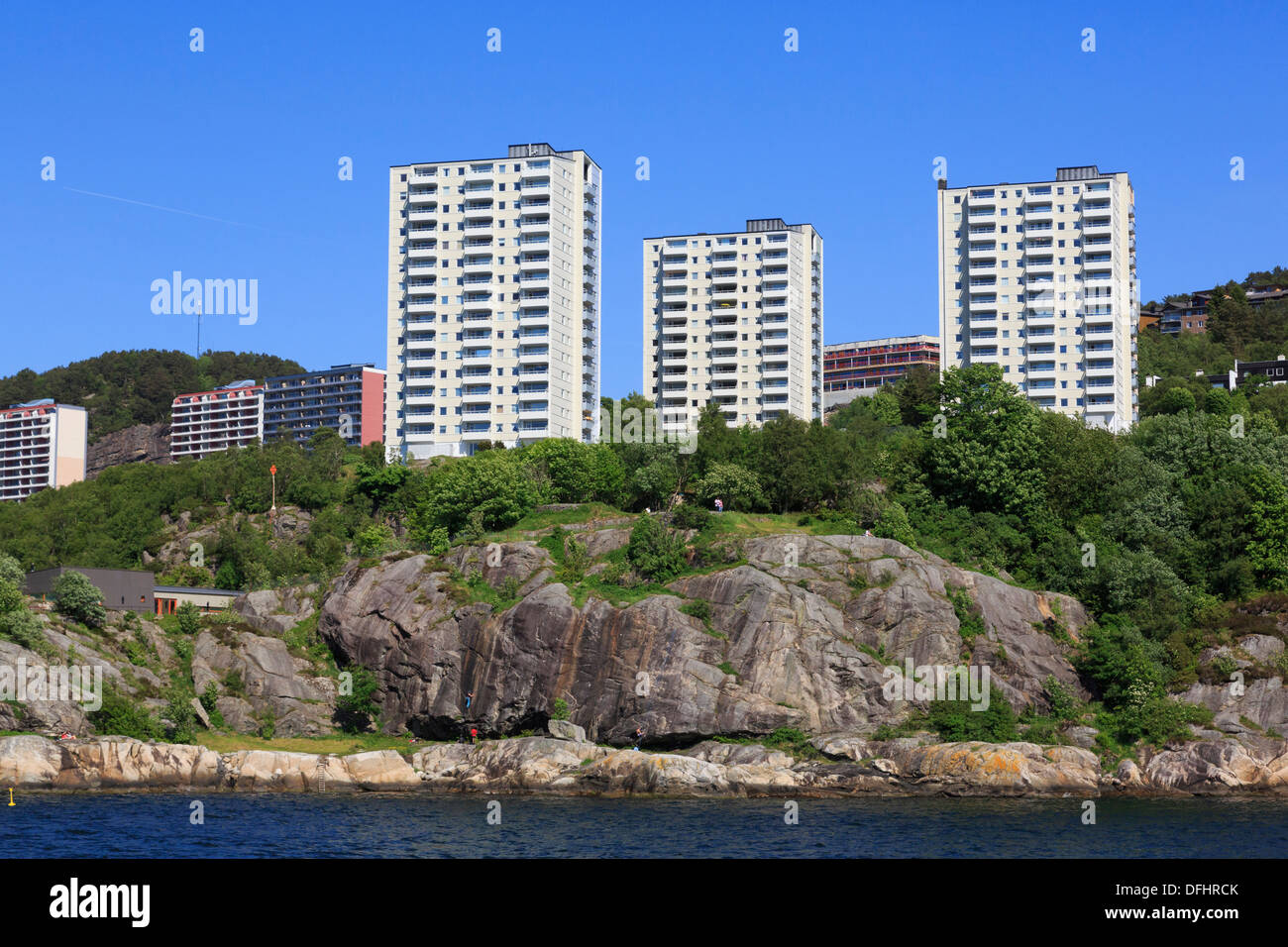 Nuova hi-rise waterfront appartamenti sopra la gente arrampicata sulle rocce lungo il fiordo Byfjorden nella periferia di Bergen, Norvegia Foto Stock
