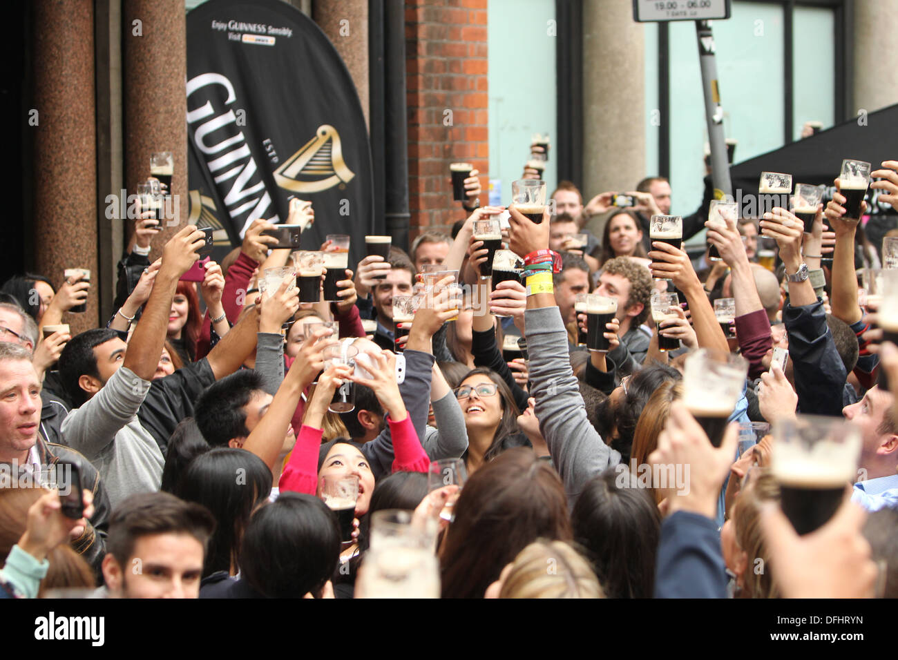 Immagine di persone in una folla holding pinte di Guinness in aria durante la Arthur's celebrazioni del Giorno Dubln nel centro citta'. Foto Stock