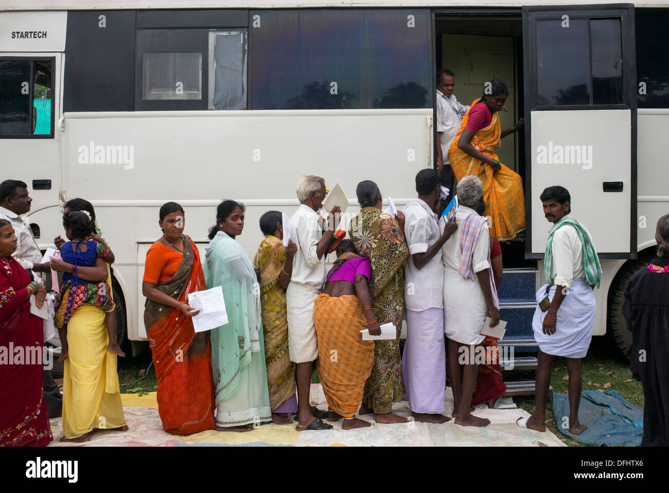 Pazienti in coda per test in Sri Sathya Sai Baba ospedale mobile bus in una zona rurale villaggio indiano. Andhra Pradesh, India Foto Stock