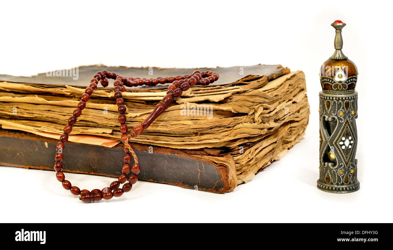 Il Sacro Corano, grani di preghiera e la vecchia bottiglia di profumo su sfondo bianco Foto Stock