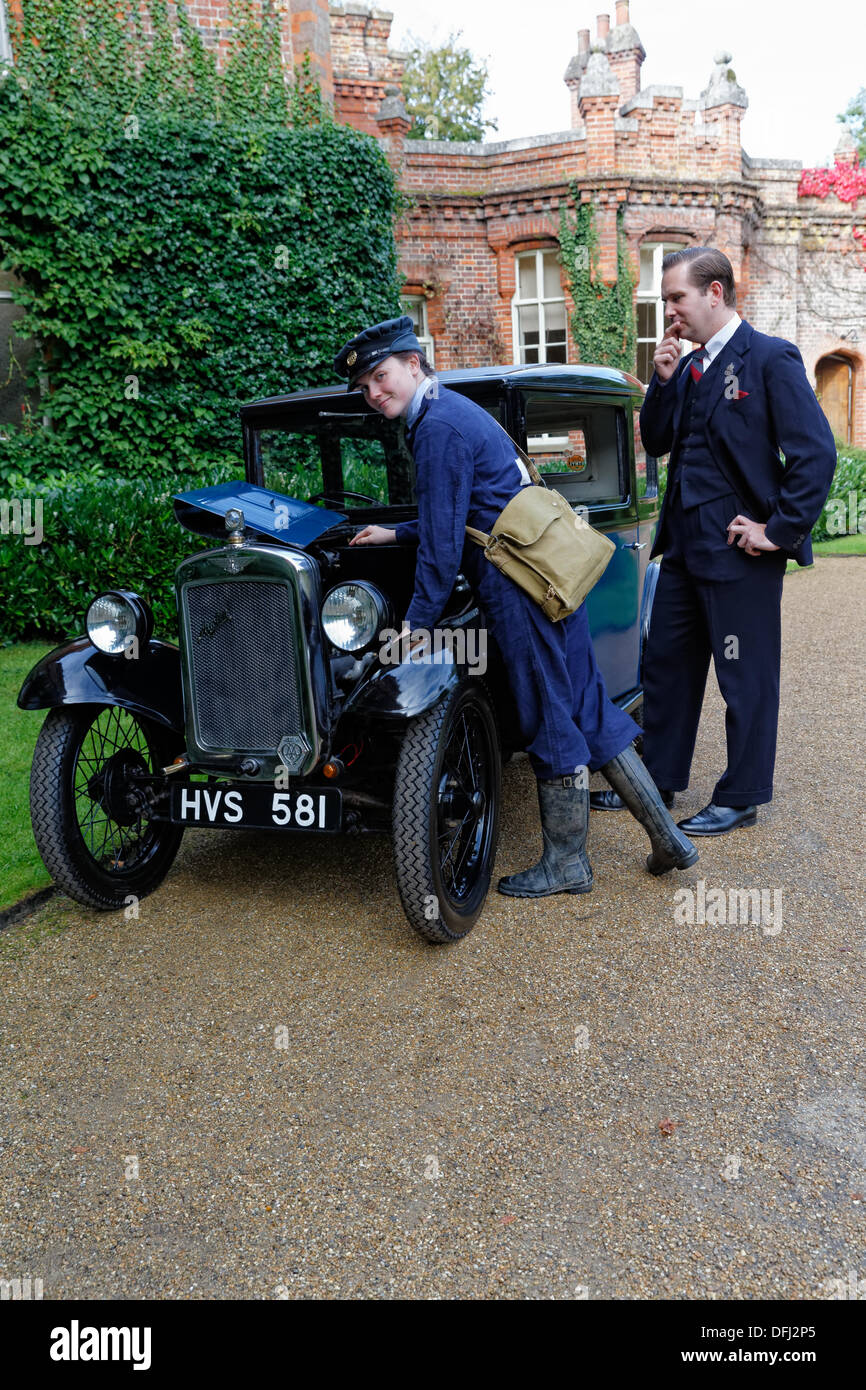 Il Sorrel Gilbert vestito come un 1943 lavorando WAF risolve un Austin 7 con un perplesso Ben Stephens ARP operaio a guardare come essi ricreano l'atmosfera degli anni quaranta a Hughenden Manor Foto Stock