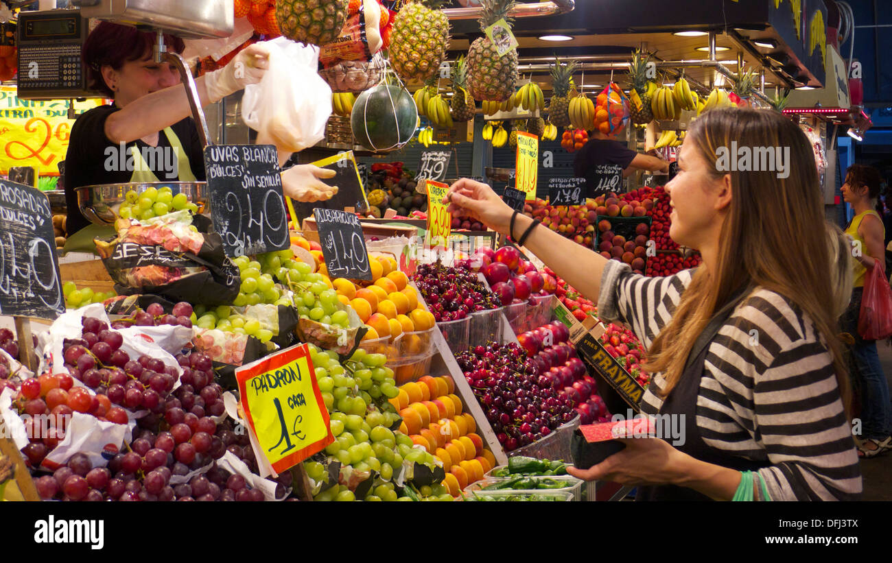 Donna acquisto da frutta e verdura in stallo del mercato La Boqueria, Las Ramblas, Barcelona, Spagna Foto Stock