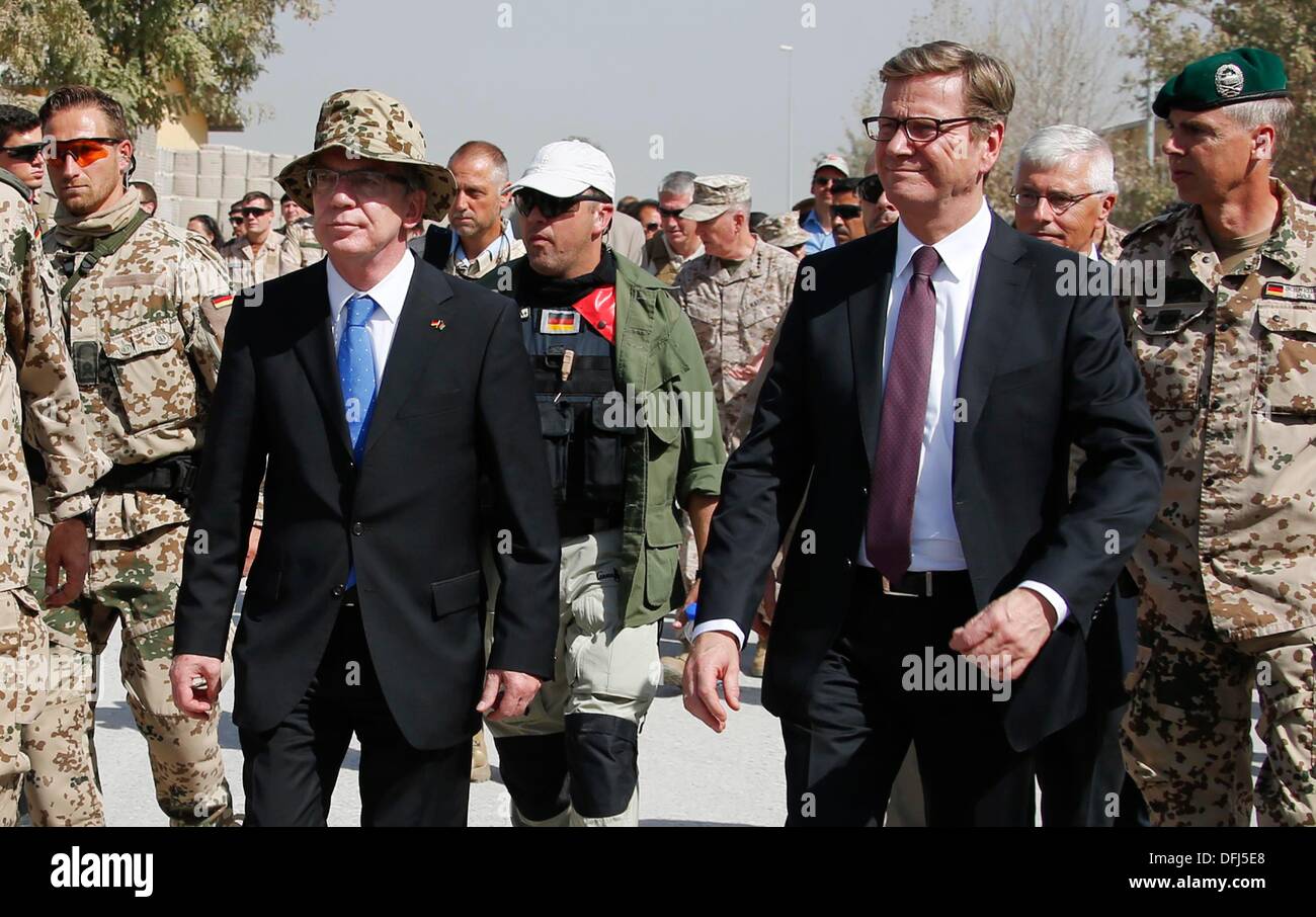 Ministro tedesco della difesa Thomas de Maiziere centro (L) e il Ministro degli esteri tedesco Guido Westerwelle (centro R) arrivano alla cerimonia di passaggio di un tedesco di base per l'Afghanistan forze armate a Kunduz Ottobre 6, 2013. Soldati della contingenza tedesco della Forza internazionale di assistenza alla sicurezza (ISAF) ha ritirato dalla loro base a Kunduz e il campo sarà utilizzato dall'Esercito nazionale afgano e la nazionale afghano di ordine civile di polizia (ANCOP). Foto: Fabrizio Bensch/dpa Foto Stock