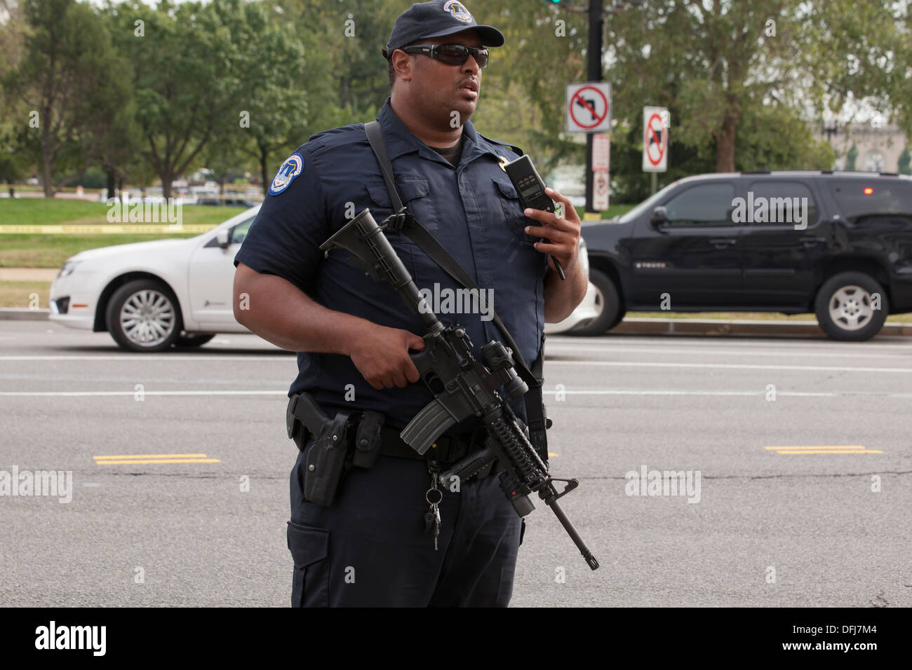 Poliziotto che trasportano un semi-auto fucile in corrispondenza di una scena del crimine - Washington DC, Stati Uniti d'America Foto Stock