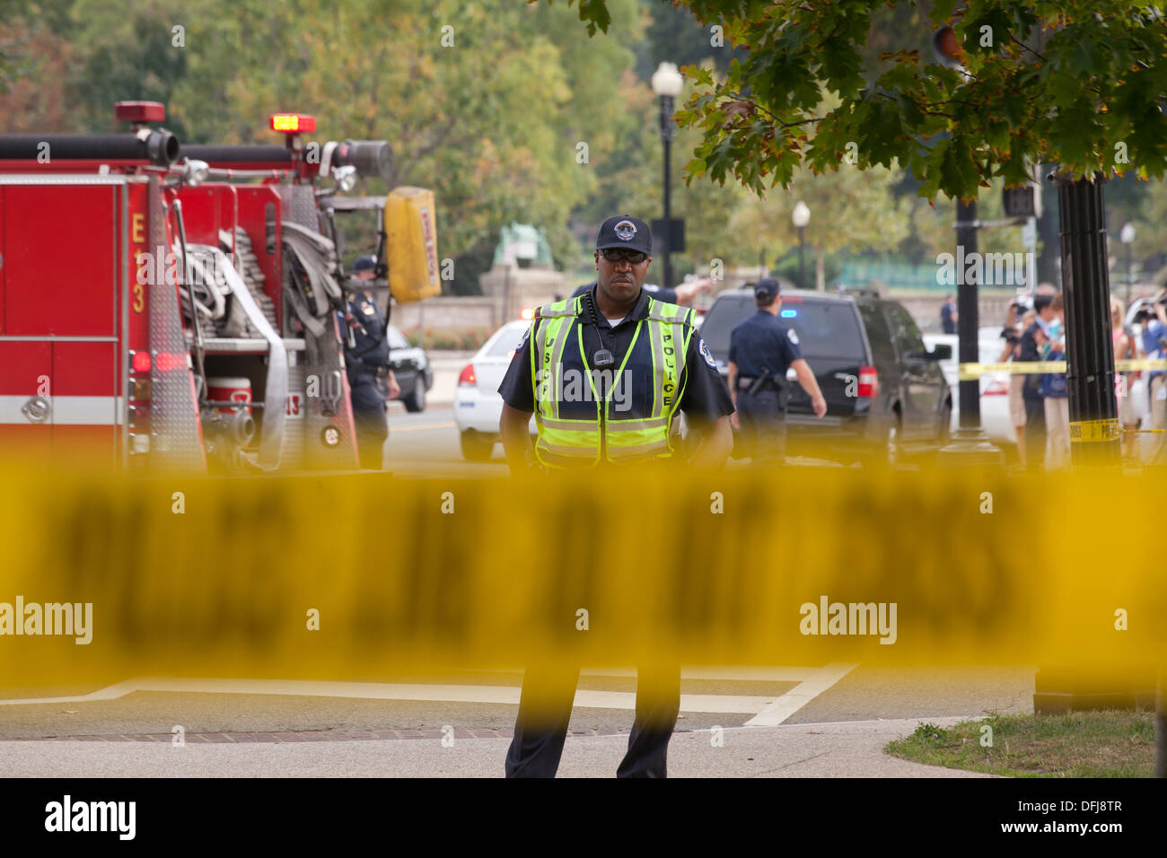 Poliziotto in piedi dietro la linea di polizia il nastro a una scena del crimine - Washington DC, Stati Uniti d'America Foto Stock