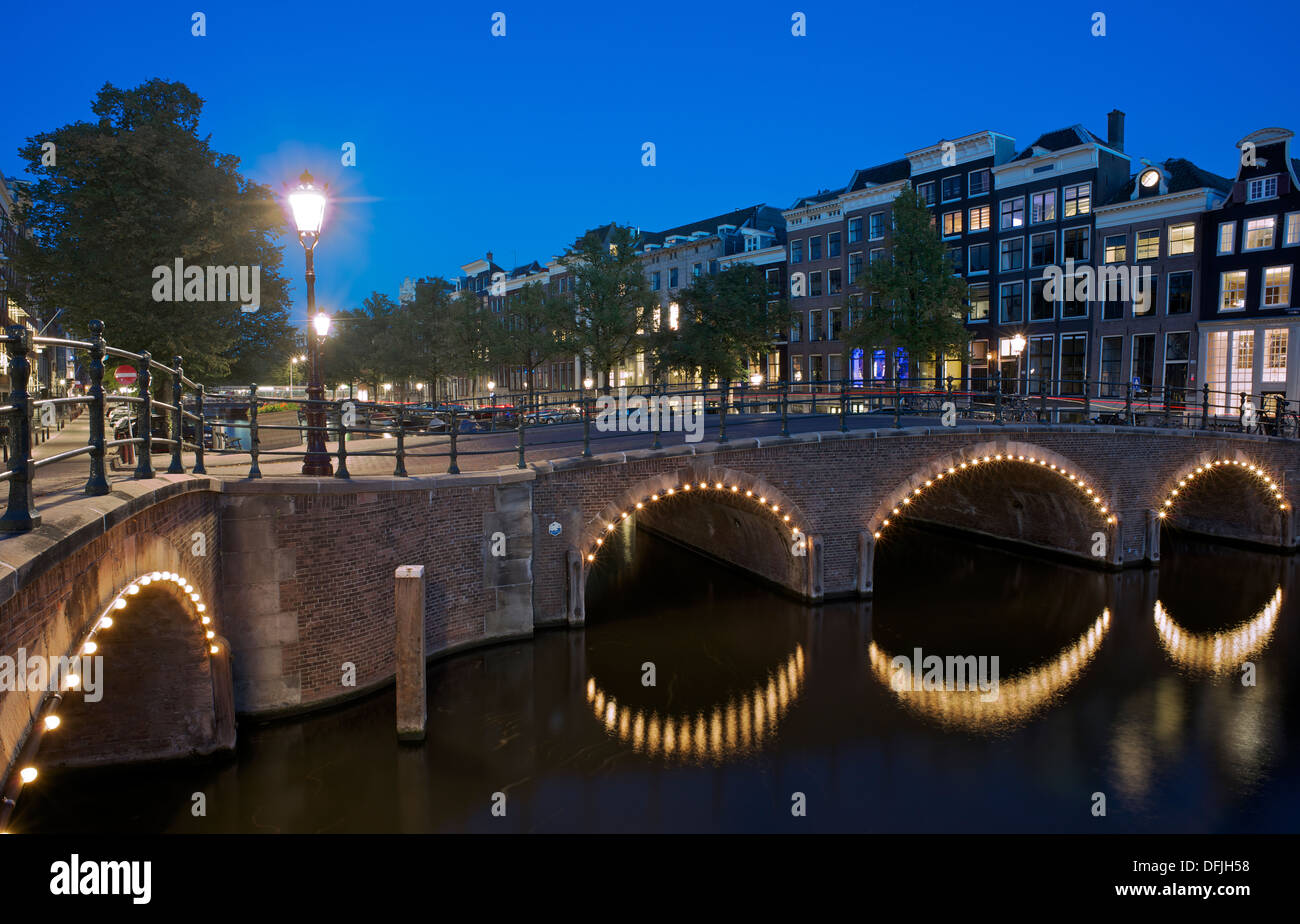 Canal ponti illuminata di notte sul Keizersgracht Amsterdam Olanda Foto Stock