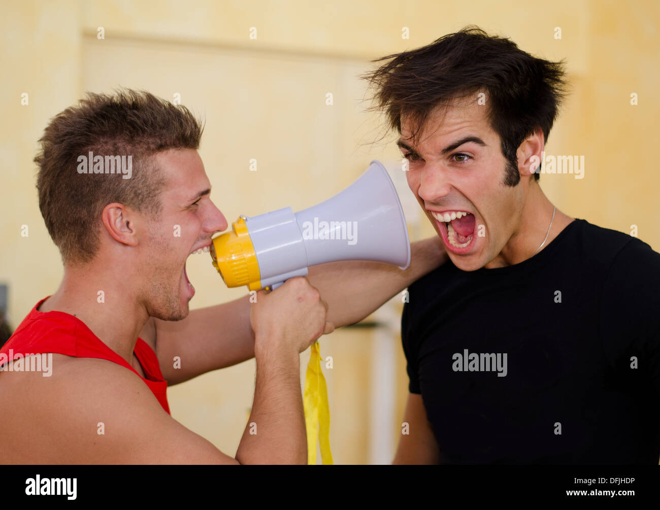 Personal trainer motivante client maschio da urlare contro di lui con megafono. Foto Stock