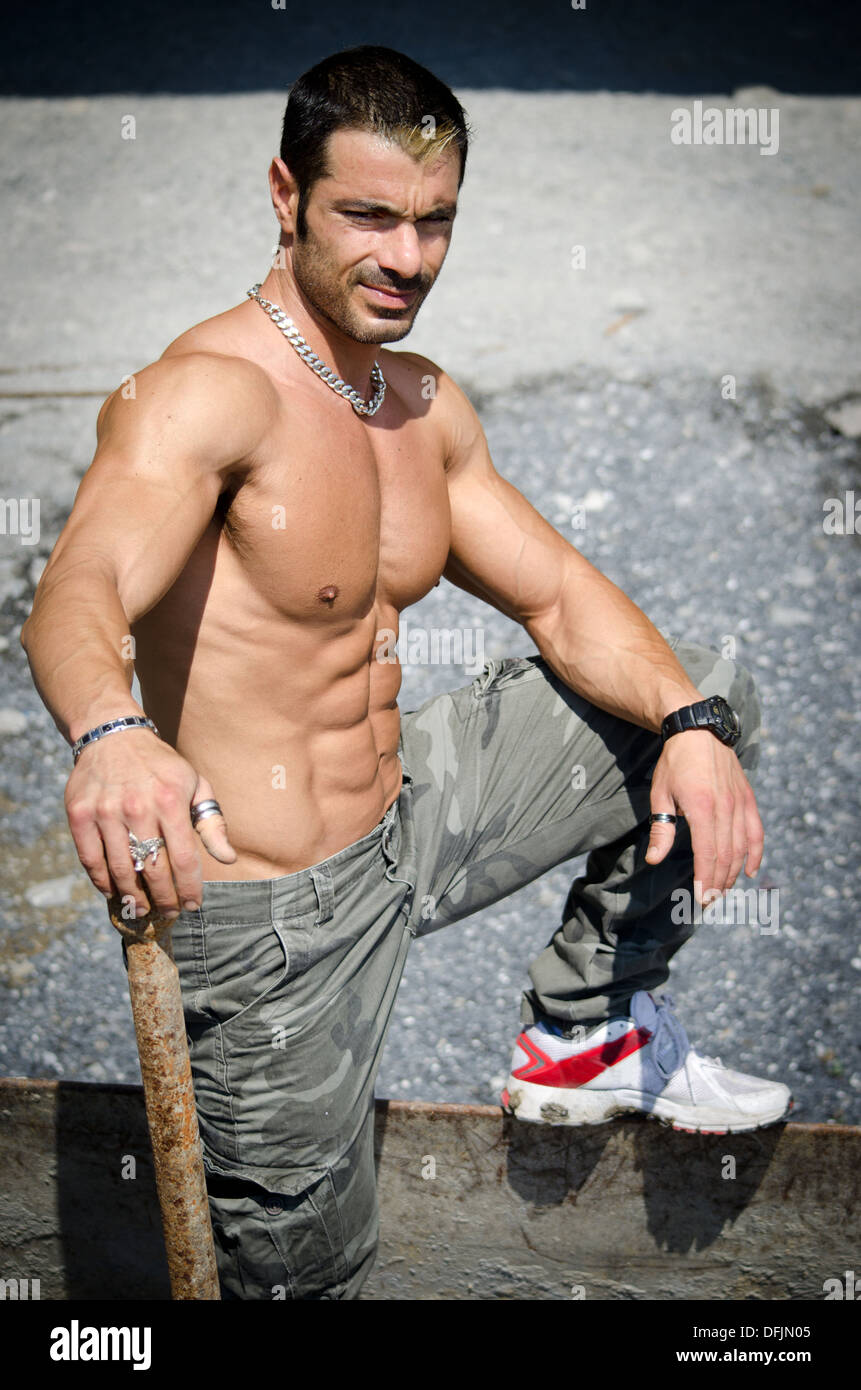 Sexy lavoratore edile shirtless, mostrando muscolare torso nudo, abs e il petto, all'aperto Foto Stock