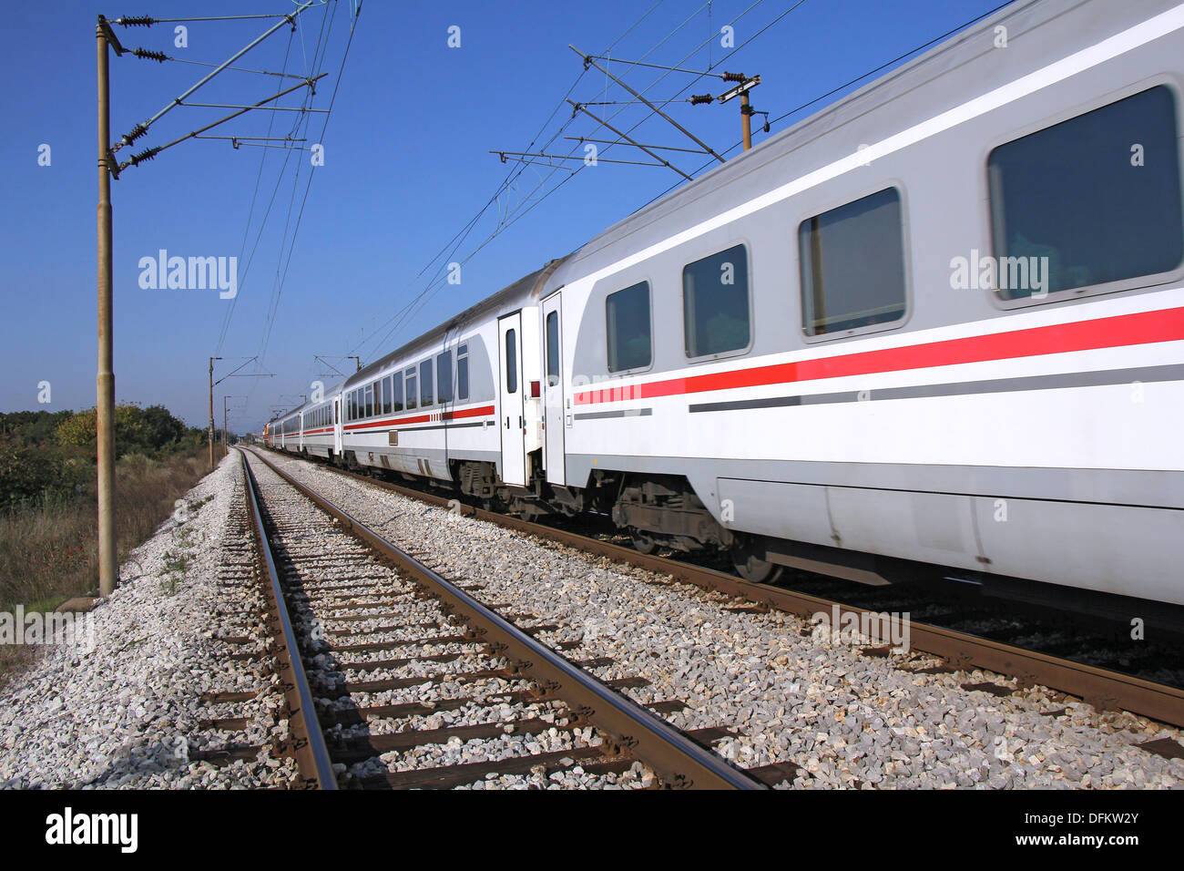 Treno passeggeri ferrovia passante in una giornata di sole Foto Stock