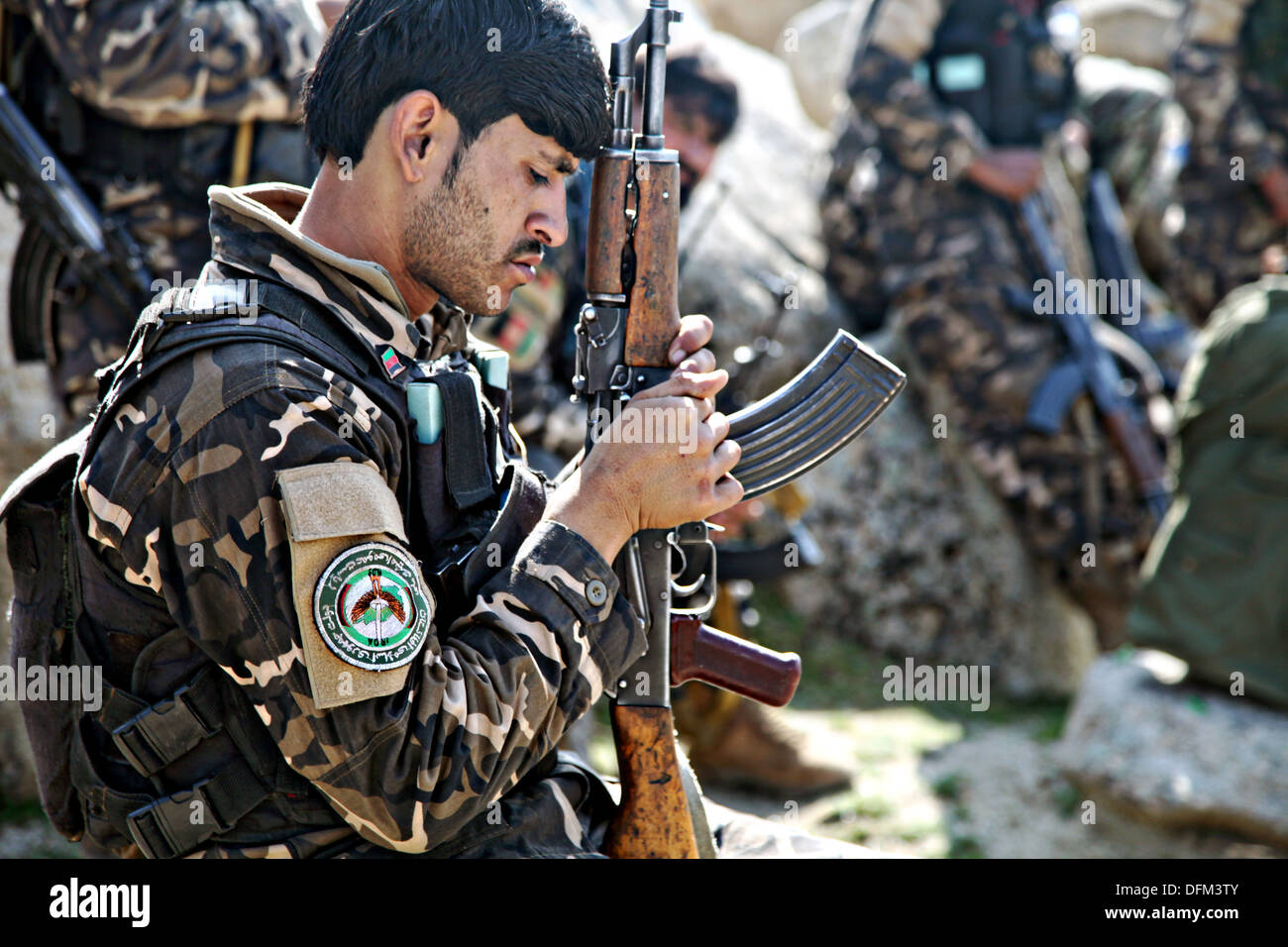 Un nazionale afghano di direzione del soldato di sicurezza esamina la sua arma dopo una missione Febbraio 20, 2013 nei pressi del villaggio di Abu Zai nella provincia di Laghman, Afghanistan. Foto Stock