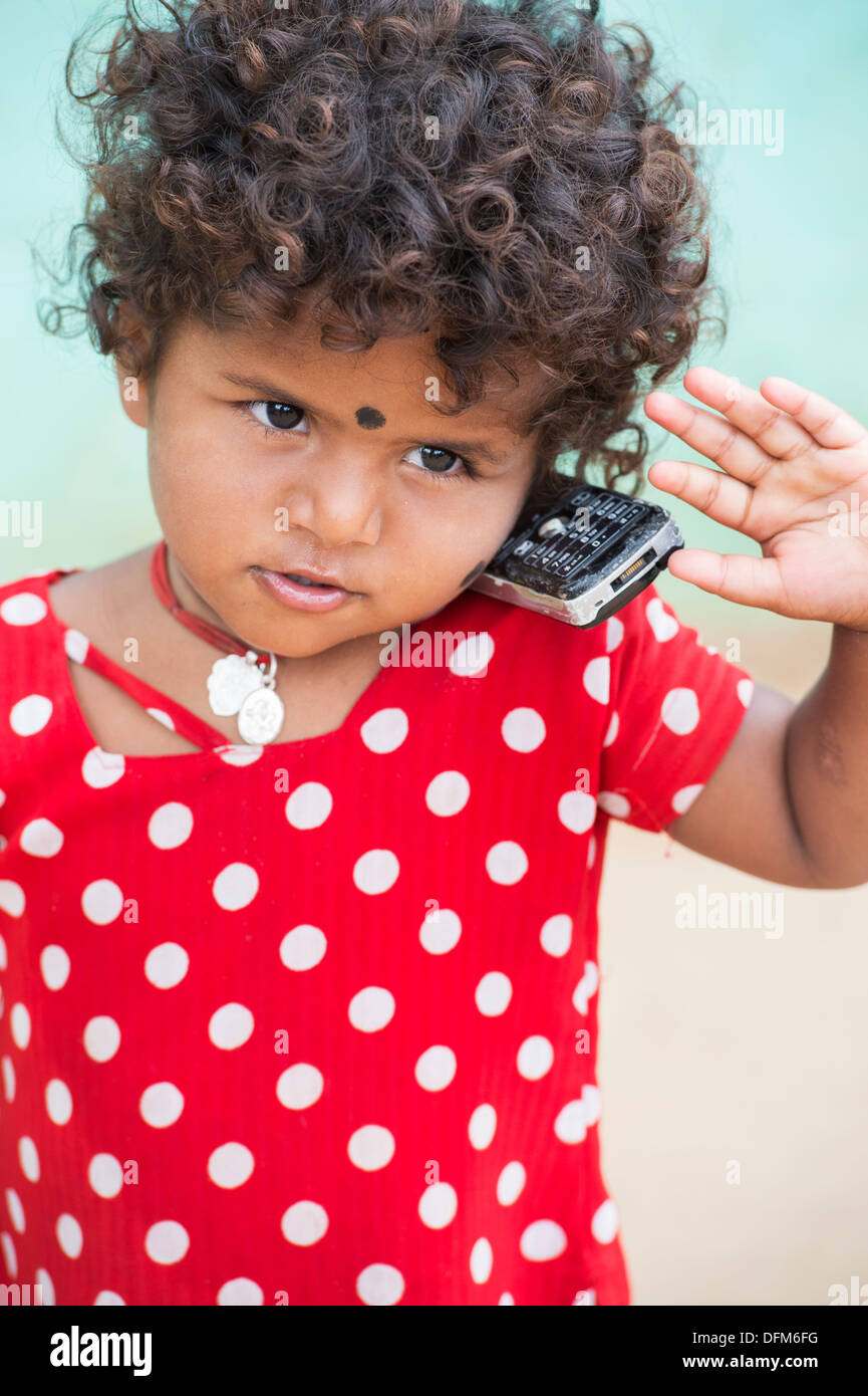 Giovane ragazza indiana / bambino dichiara di utilizzare un telefono cellulare in un territorio rurale villaggio indiano. Andhra Pradesh, India Foto Stock