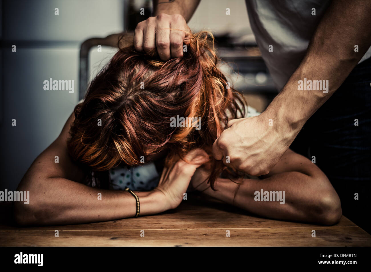 L'uomo tirando i capelli di sua moglie e che minacciano di pugno Foto Stock