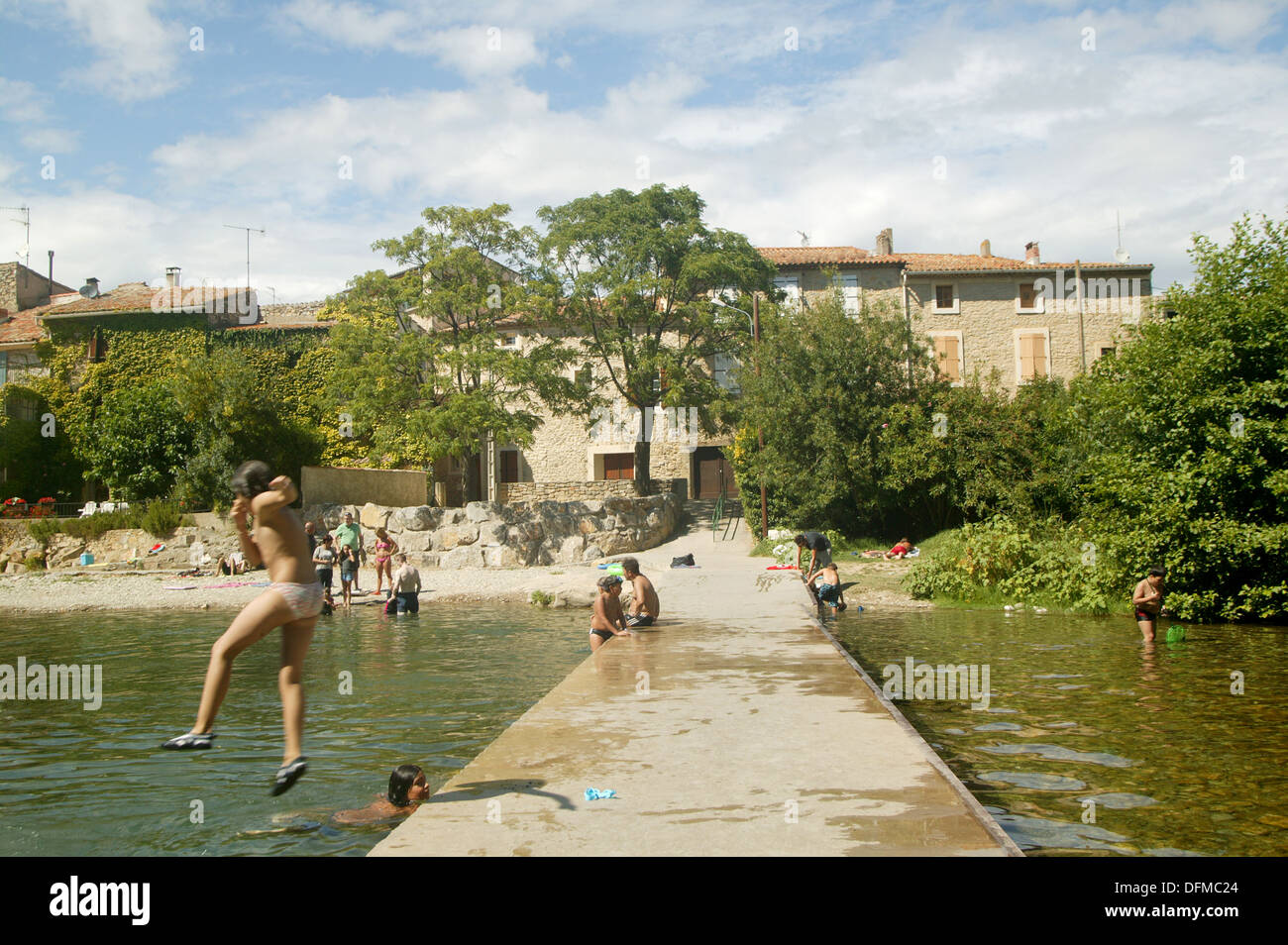 Un caldo giorno d'estate in Francia rurale. una tipica giornata nella vita di un bambino europeo giocando nel fiume locale Foto Stock