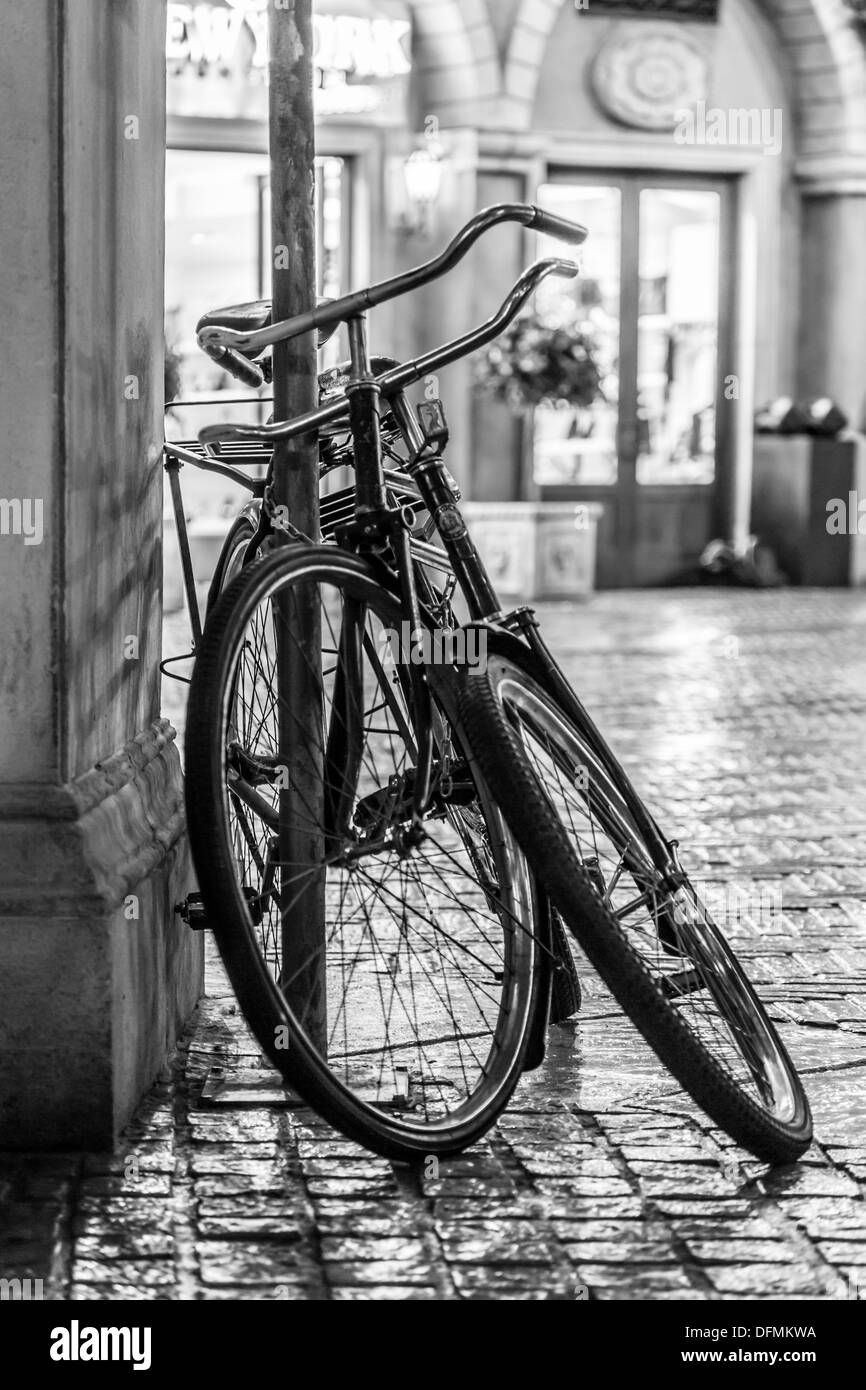 Due vecchie biciclette legato ad un palo sul lato della strada Foto Stock