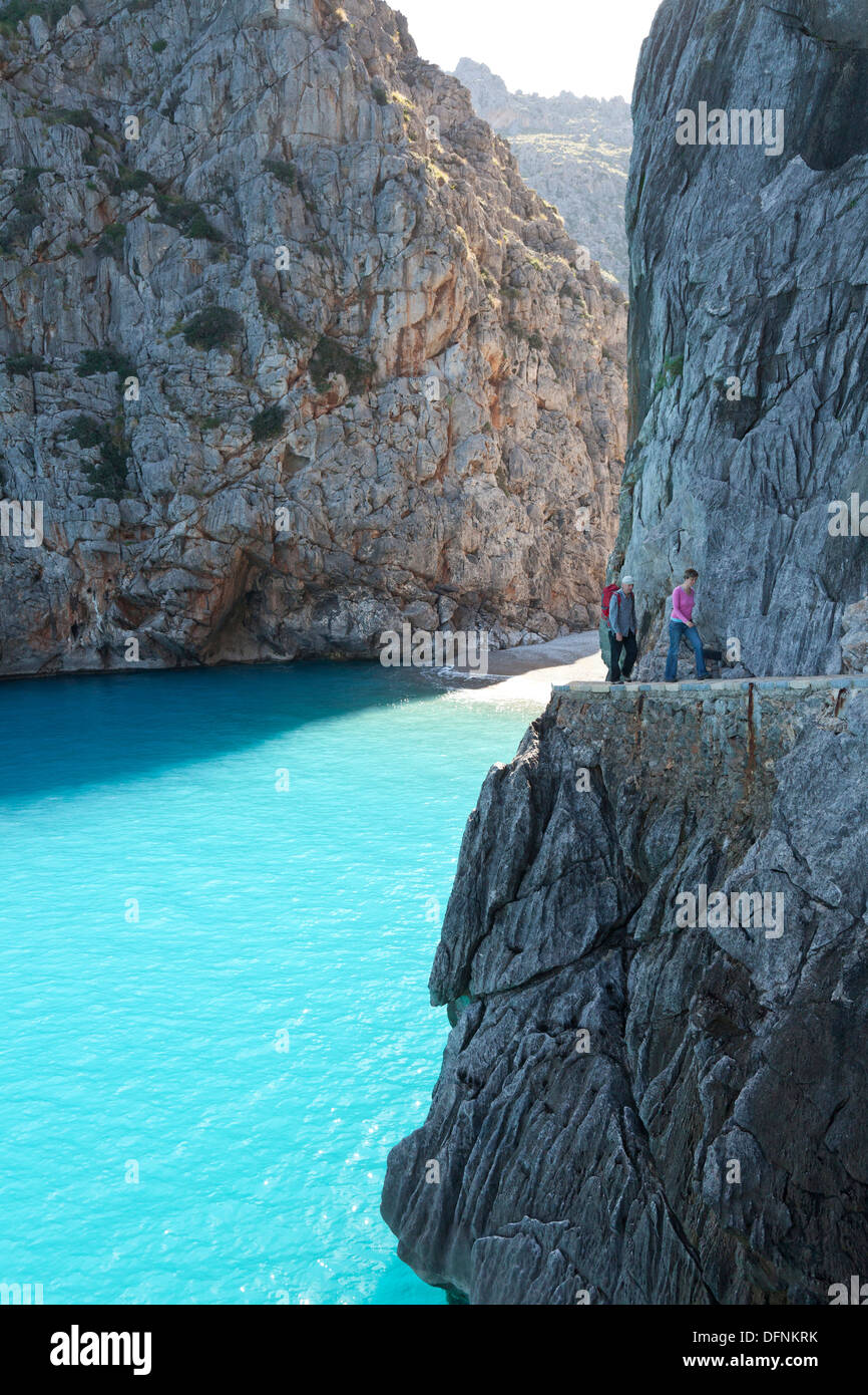 Gli escursionisti sopra la baia di Sa Calobra, Cala de Sa Calobra, fine del canyon Torrent de Pareis, romantica spiaggia, Serra de Tramuntana Foto Stock