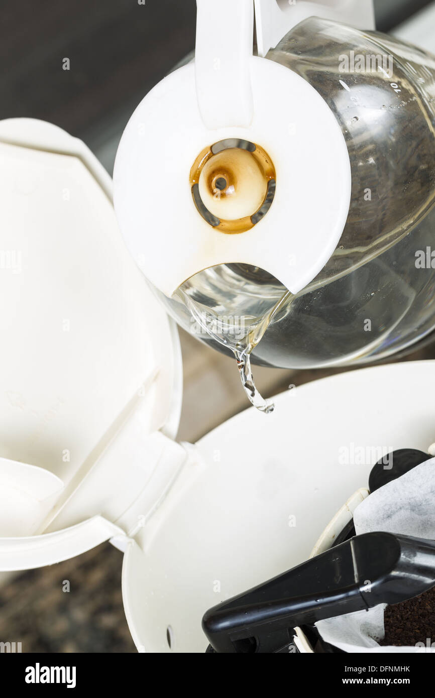 Foto verticale di acqua versata, dal caffè nella macchina per caffè con caffè fresco motivi in bianco caffè sbiancato filt Foto Stock