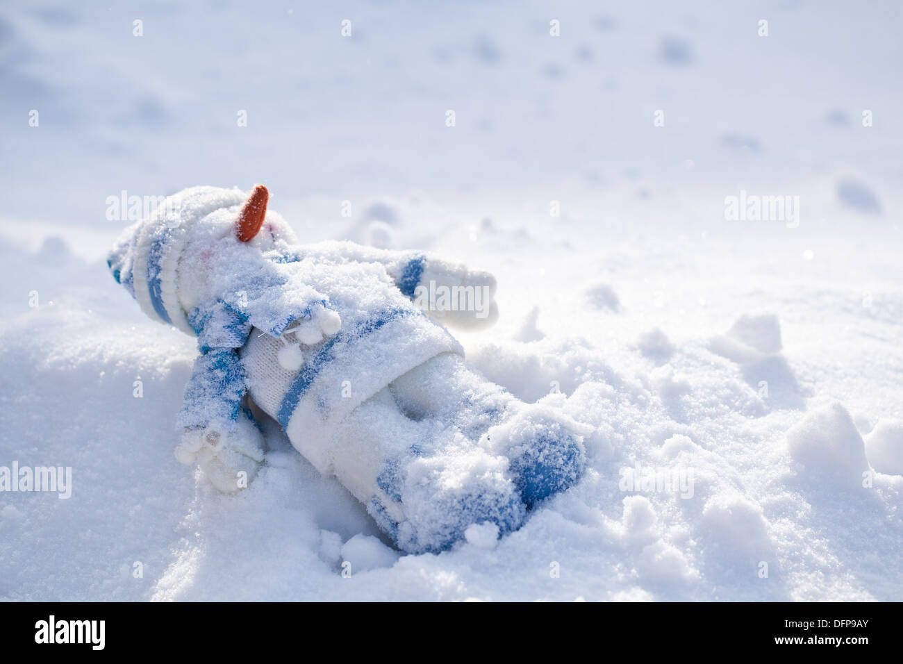Poco pupazzo di neve con la carota naso nella neve. Foto Stock