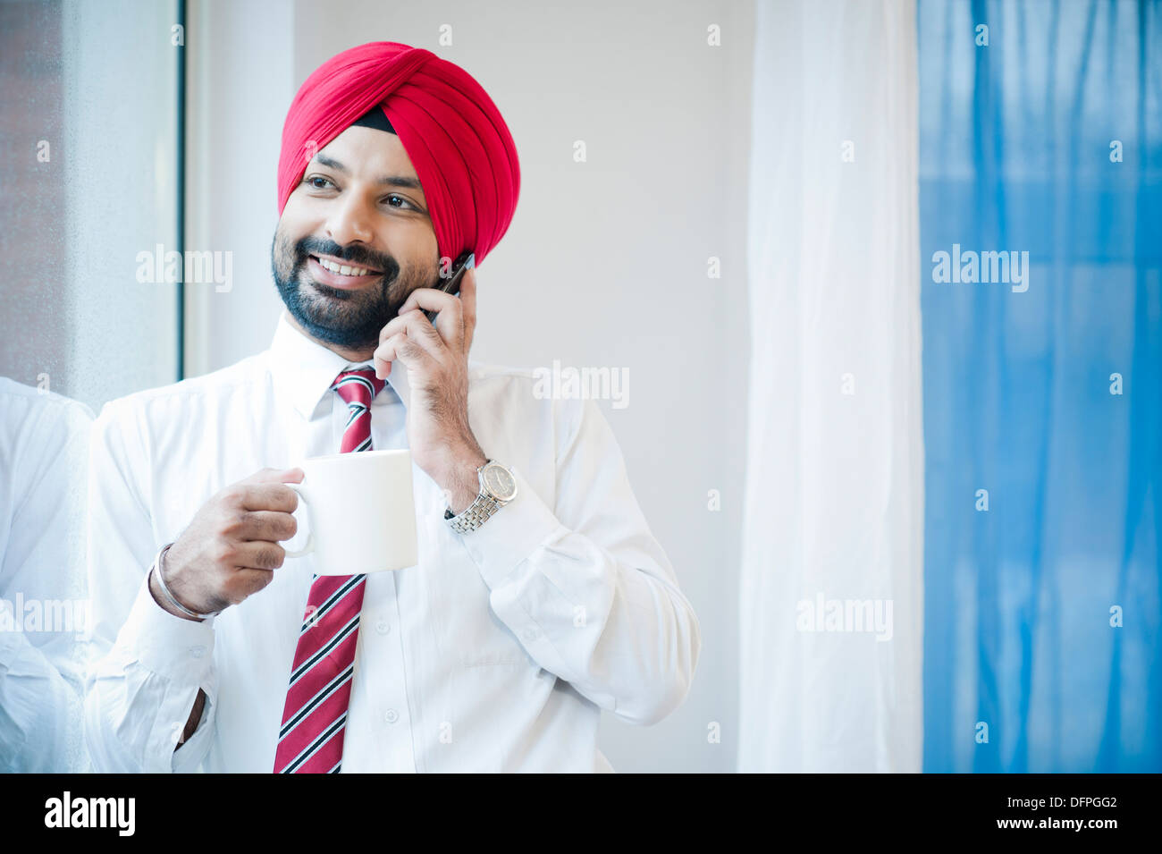 Imprenditore a bere caffè e a parlare su un telefono mobile Foto Stock