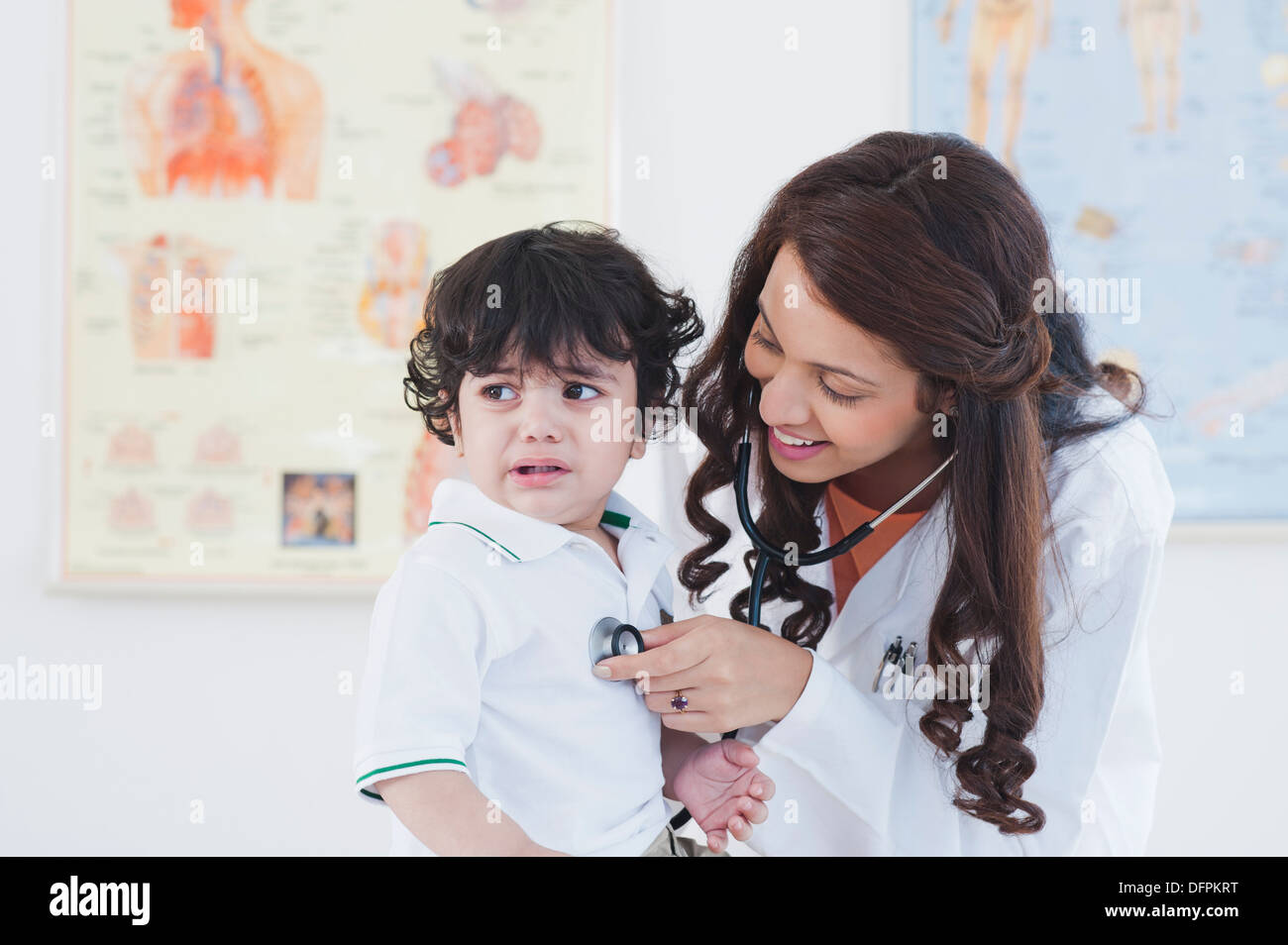 Medico donna esaminando un bambino con uno stetoscopio Foto Stock