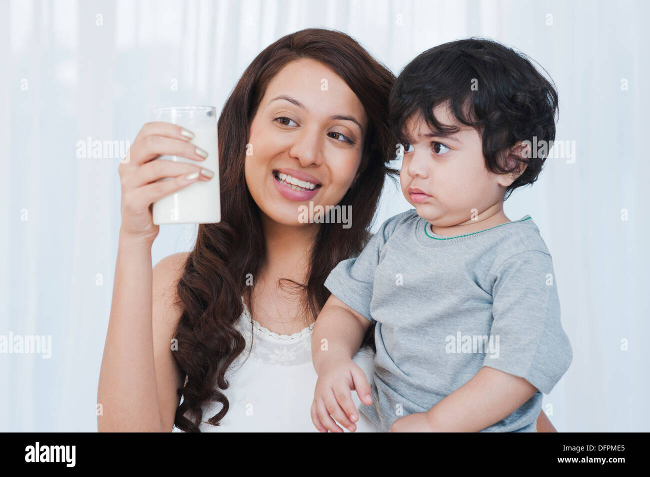 Donna sorridente che mostra il latte per suo figlio Foto Stock
