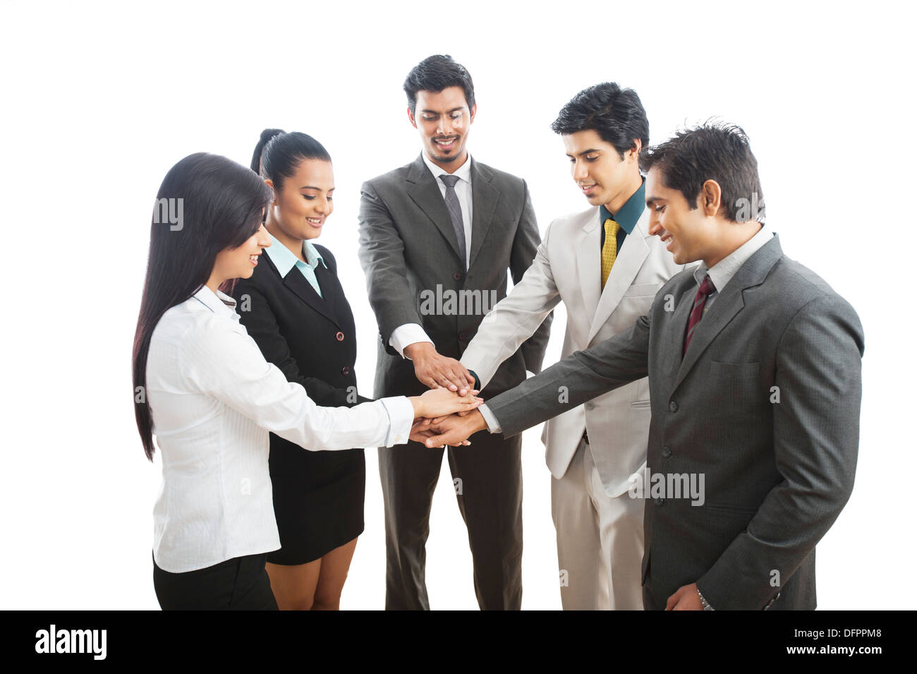I dirigenti aziendali stacking le loro mani e sorridente Foto Stock