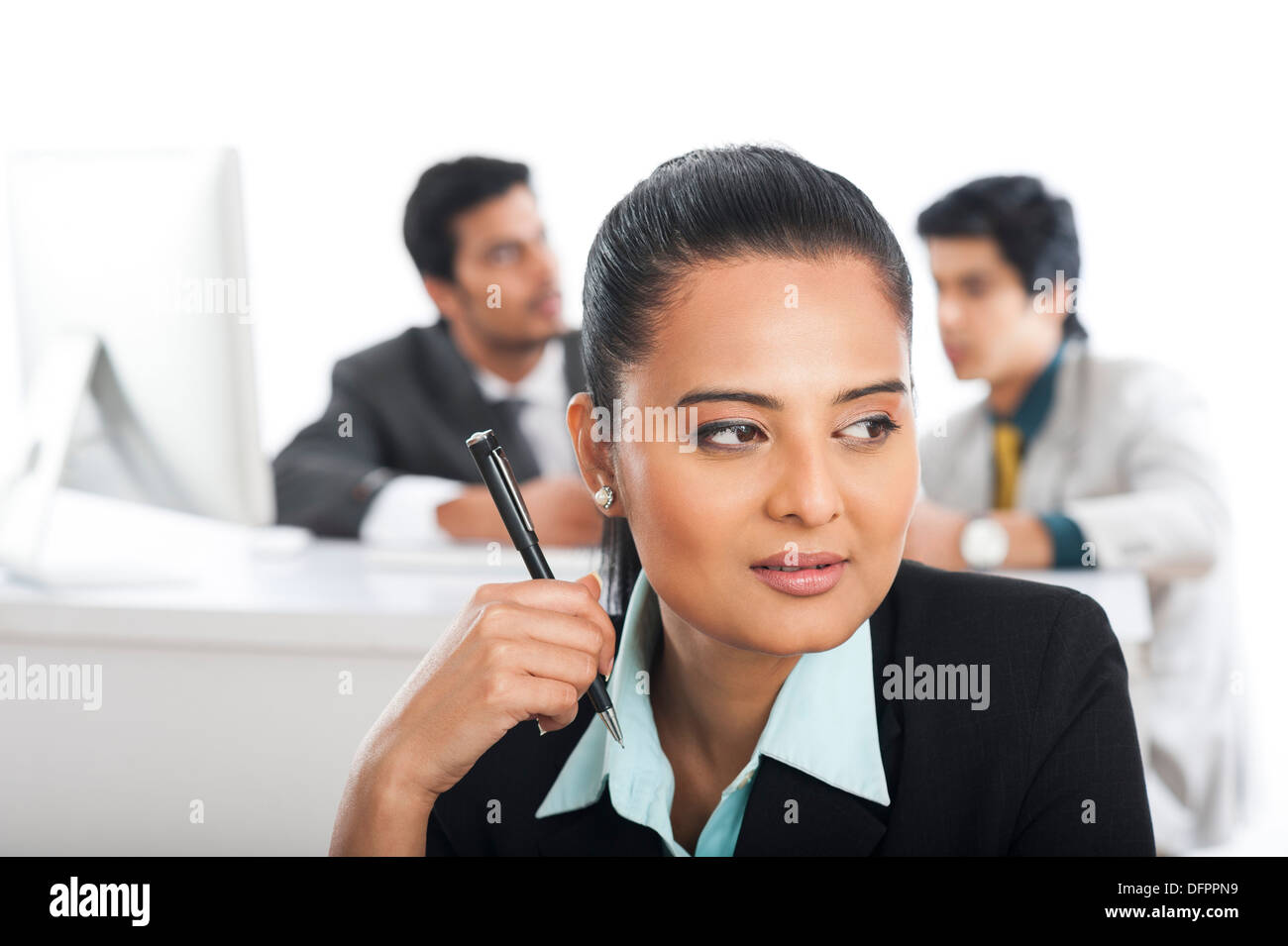 Close-up di una imprenditrice tenendo una penna con i suoi colleghi in background Foto Stock