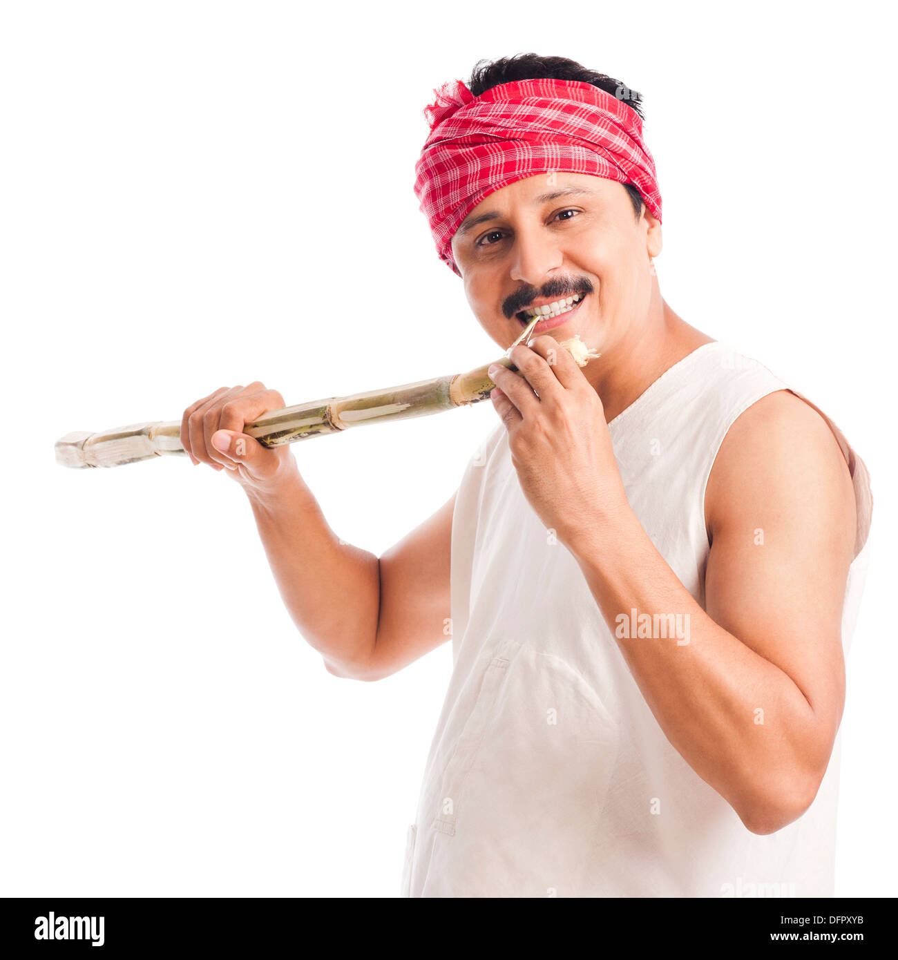 Ritratto di un agricoltore di mangiare la canna da zucchero e sorridente Foto Stock