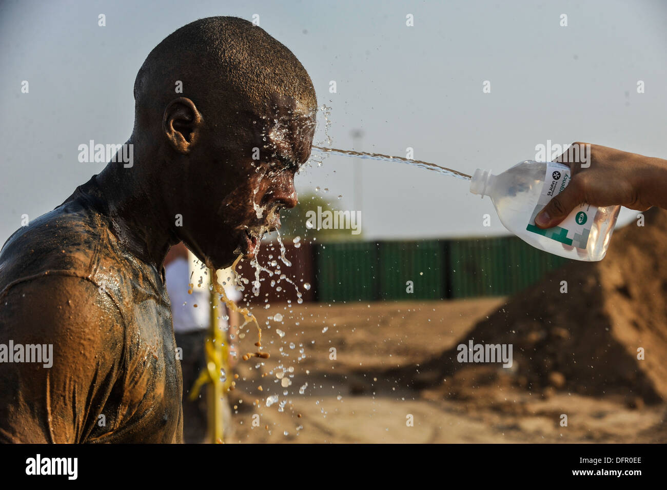 CAMP LEMONNIER, Gibuti (sett. 28, 2013) Un concorrente ha gli occhi sciacquati dopo strisciando attraverso un pozzo del fango durante il 5K fango eseguire presso il Camp Lemonnier. Foto Stock