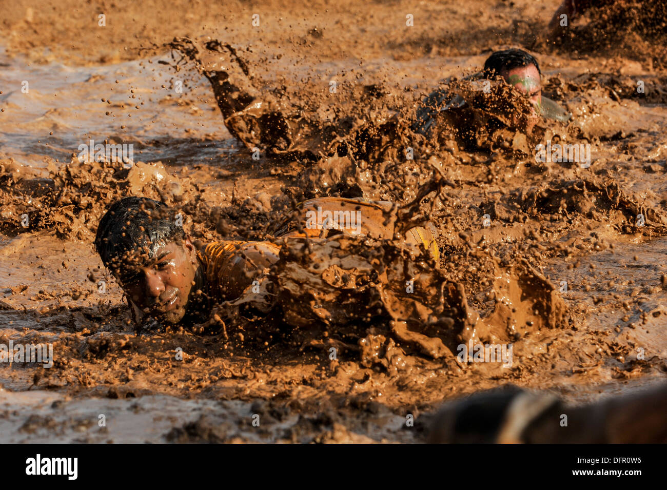 CAMP LEMONNIER, Gibuti (sett. 28, 2013) Concorrenti strisciare in un pozzo del fango durante il 5K fango eseguire presso il Camp Lemonnier. Foto Stock