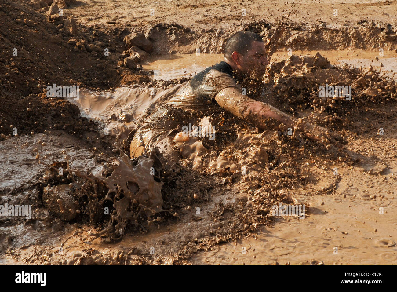 CAMP LEMONNIER, Gibuti (sett. 28, 2013) Un concorrente cade in una buca di fango durante il 5K fango eseguire presso il Camp Lemonnier. Foto Stock