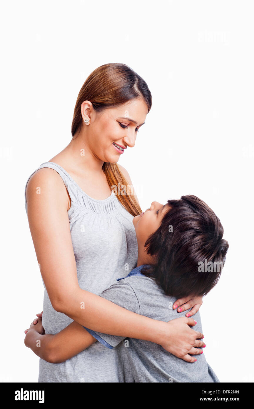 Donna e suo figlio abbraccia ogni altra e sorridente Foto Stock