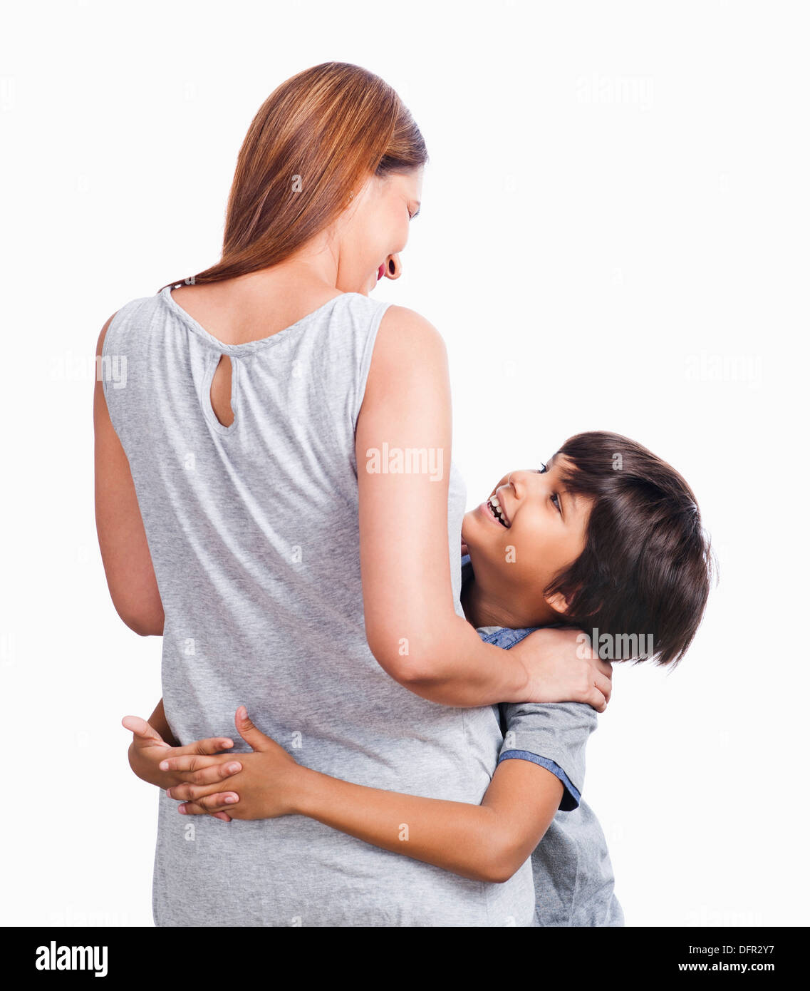 Ragazzo abbraccia il suo madre e sorridente Foto Stock