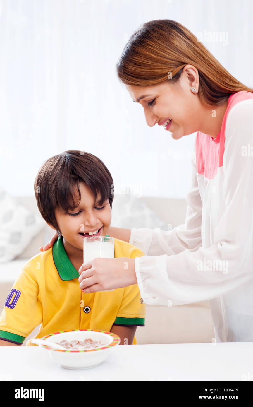 Donna sorridente alimentando il latte per suo figlio Foto Stock