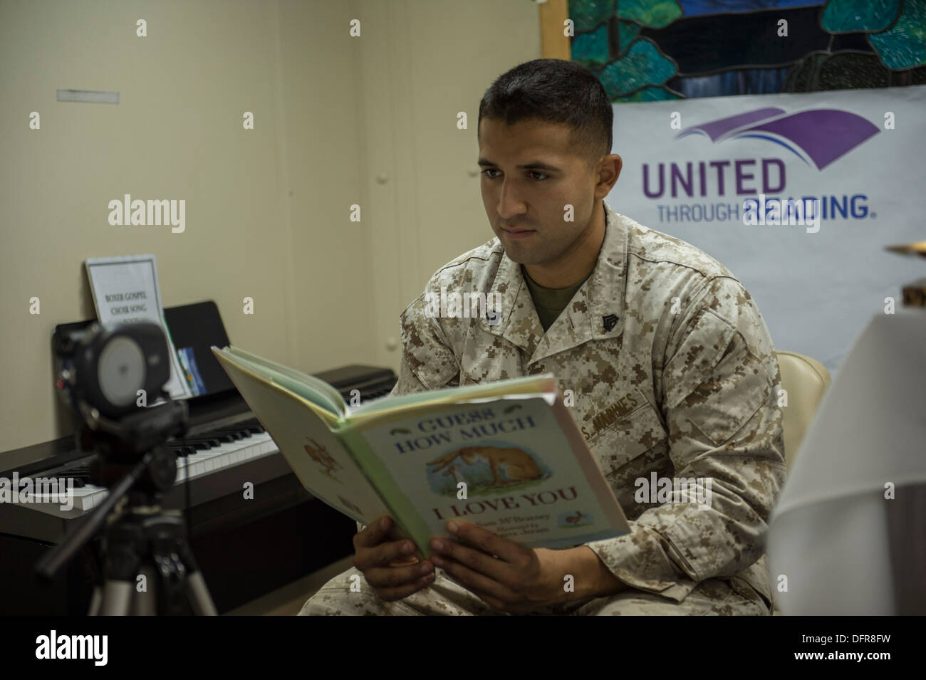 Sgt. Marcos Luna registra se stesso la lettura di un libro per bambini come parte del Regno attraverso il programma di lettura a bordo il anfibi Foto Stock
