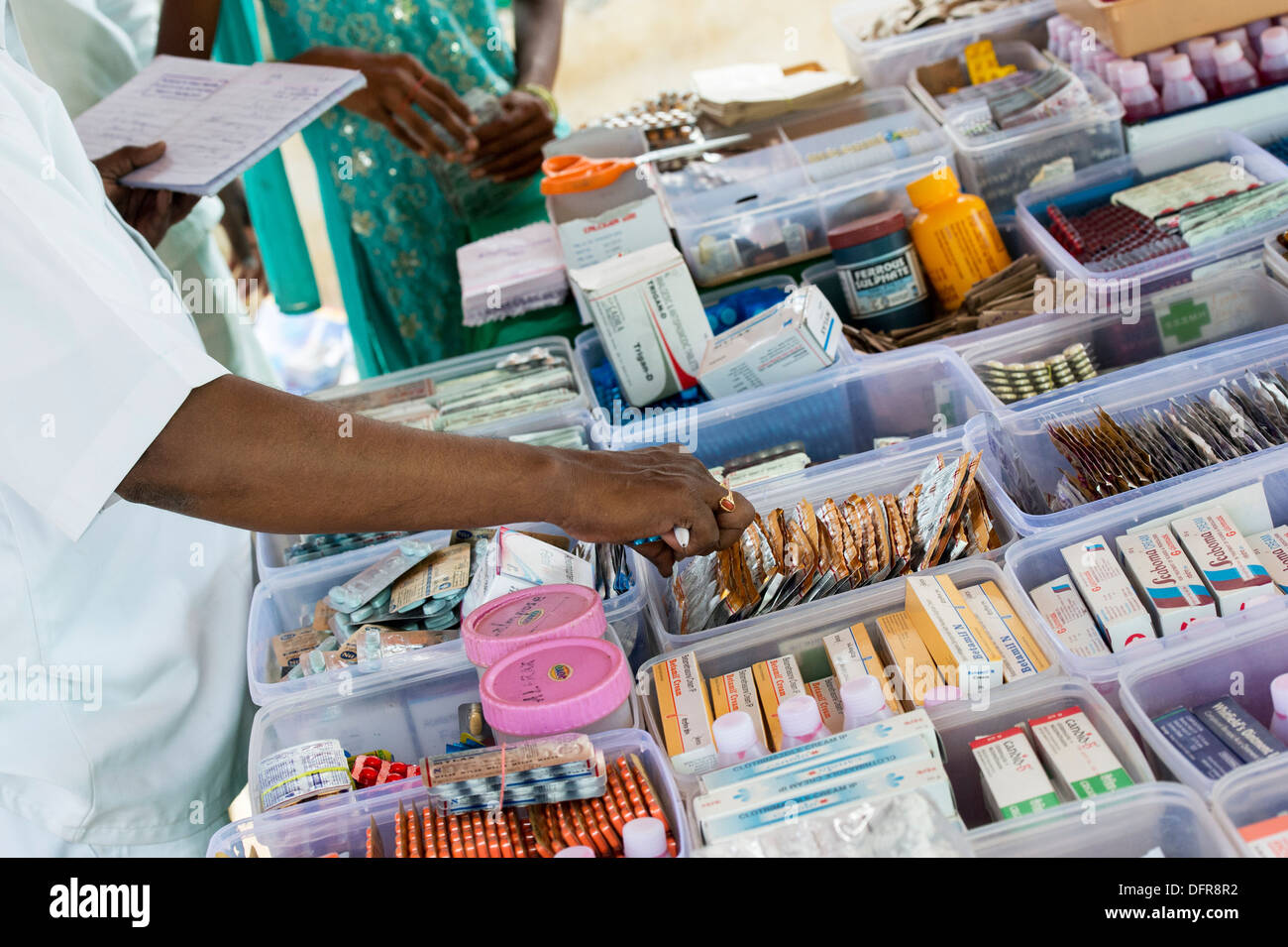 Farmacisti libero di erogazione dei farmaci per la donna indiana al Sri Sathya Sai Baba outreach mobile farmacia ospedaliera. India Foto Stock