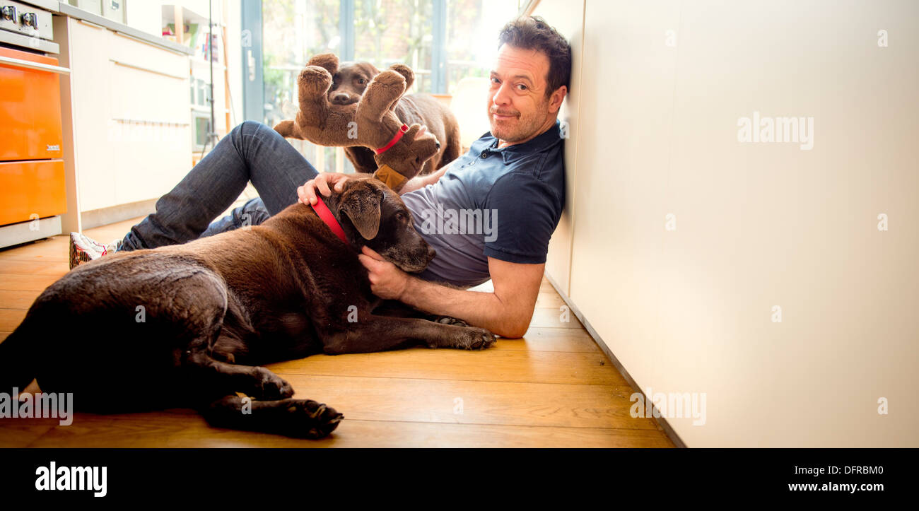 Fashion designer Andrea Fionda al suo Sussex home 2013. Con uno dei suoi cani in cucina. Foto Stock