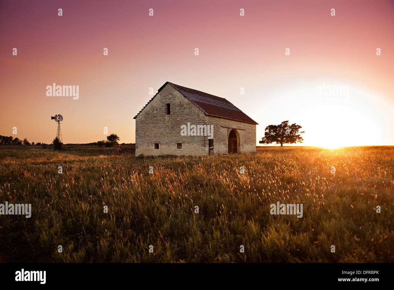 Un fienile in pietra si erge deglected al tramonto. in selce colline del sud del Kansas, Stati Uniti d'America. Foto Stock