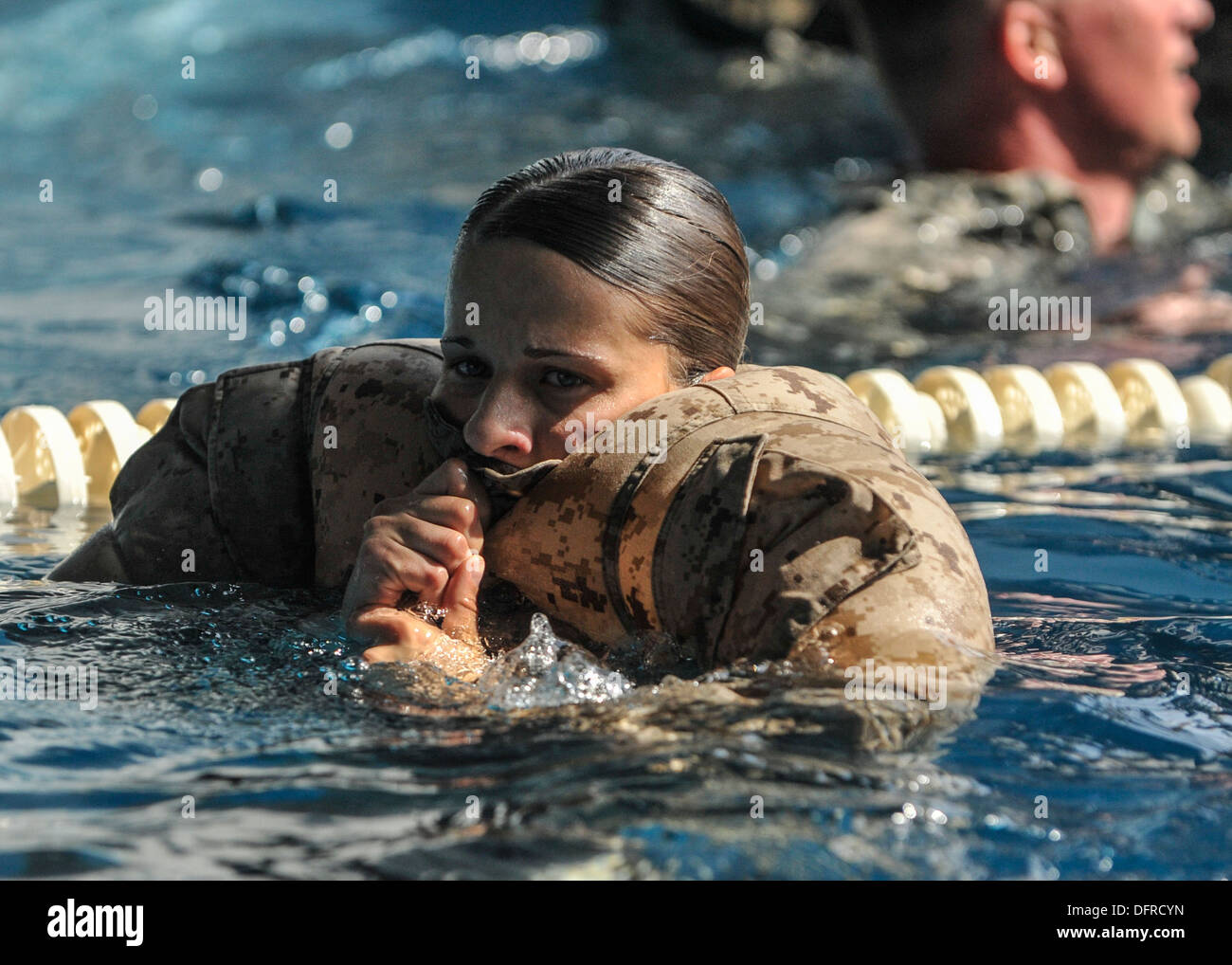 Marine Corps Sgt. Jennifer Slown gonfia la sua camicetta uniforme mentre il piano di calpestio acqua durante un relè nuotare gara. I concorrenti nuotato su Foto Stock