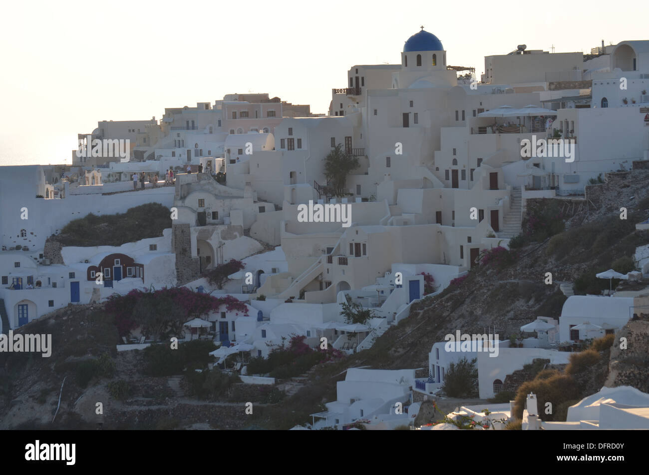 Oia,sull isola di Santorini. La piccola chiesa greca guarda oltre le numerose case e alberghi costruiti dove la grande esplosione nel 1628 BC Foto Stock