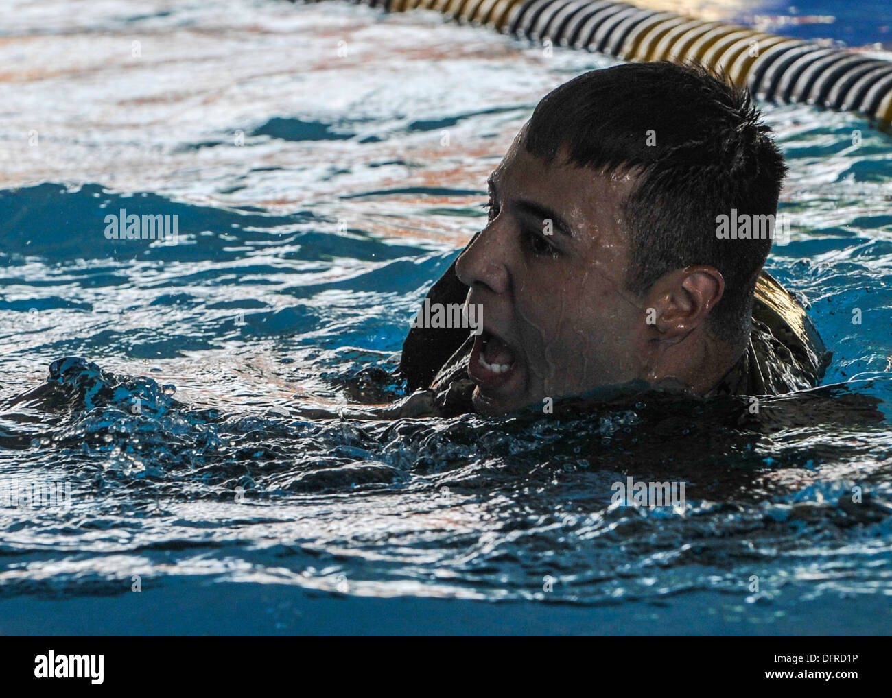 Navy Corpsman ospedale di terza classe Javier Uvina nuota durante un relè nuotare gara. I concorrenti nuotarono per un giro della piscina mentre wearin Foto Stock