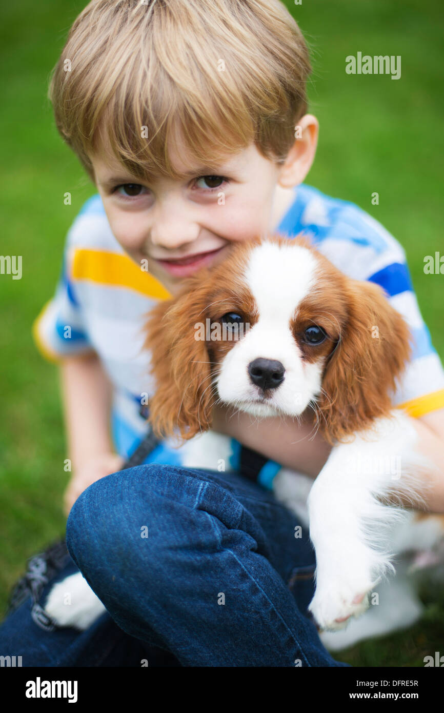 Ragazzo con Pet King Charles Spaniel cucciolo di cane Foto Stock