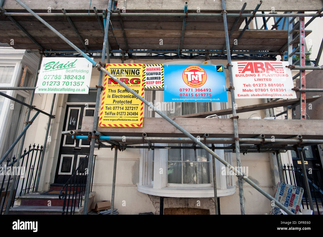 Costruttori' pannelli pubblicitari sui ponteggi su un 1822 costruito Regency House in restauro nel centro di Brighton. Foto Stock