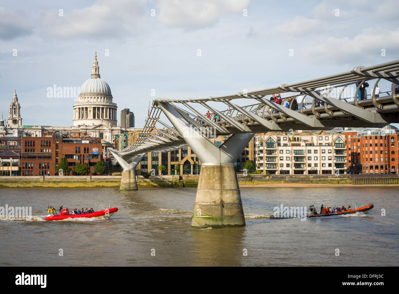 Due barche di nervatura di passare sotto il Millennium Bridge e la Cattedrale di San Paolo, il fiume Tamigi e città di Londra, Regno Unito Foto Stock