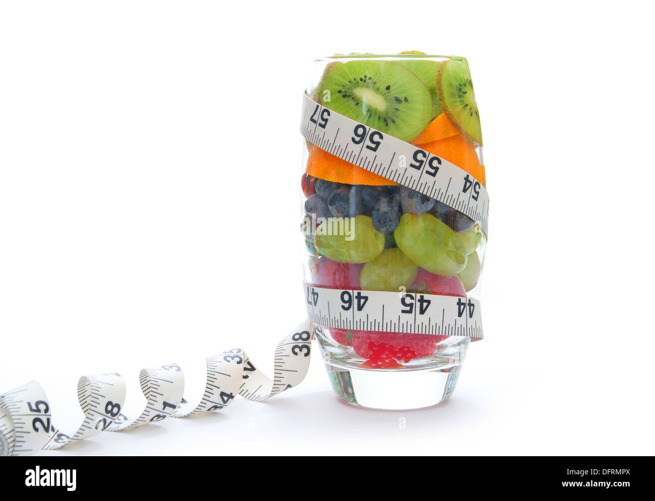 Cinque al giorno frutte imballate all'interno di un vetro con un nastro di misurazione Foto Stock