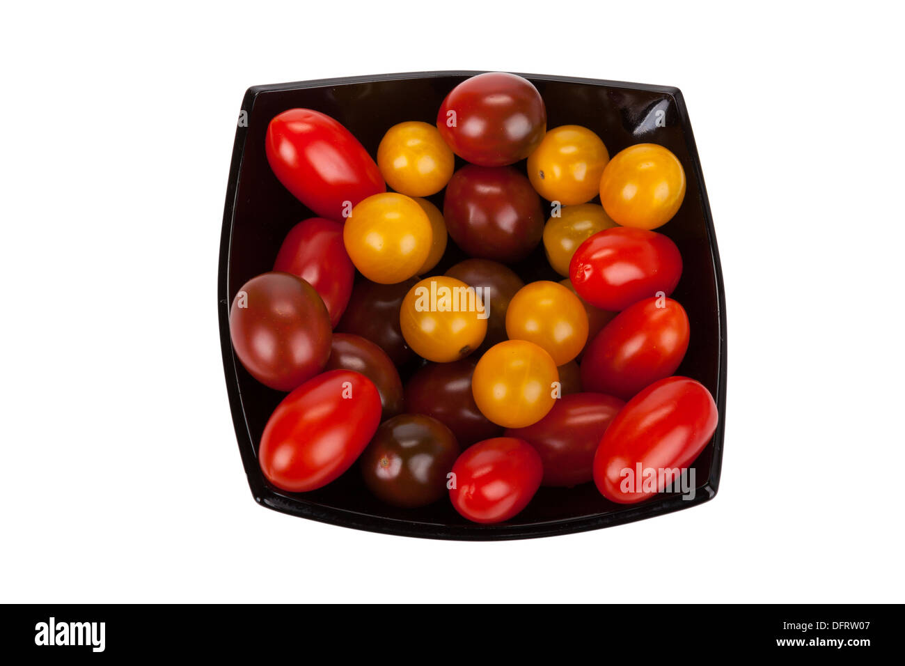 Pomodori ciliegia in piastra nera isolati su sfondo bianco Foto Stock