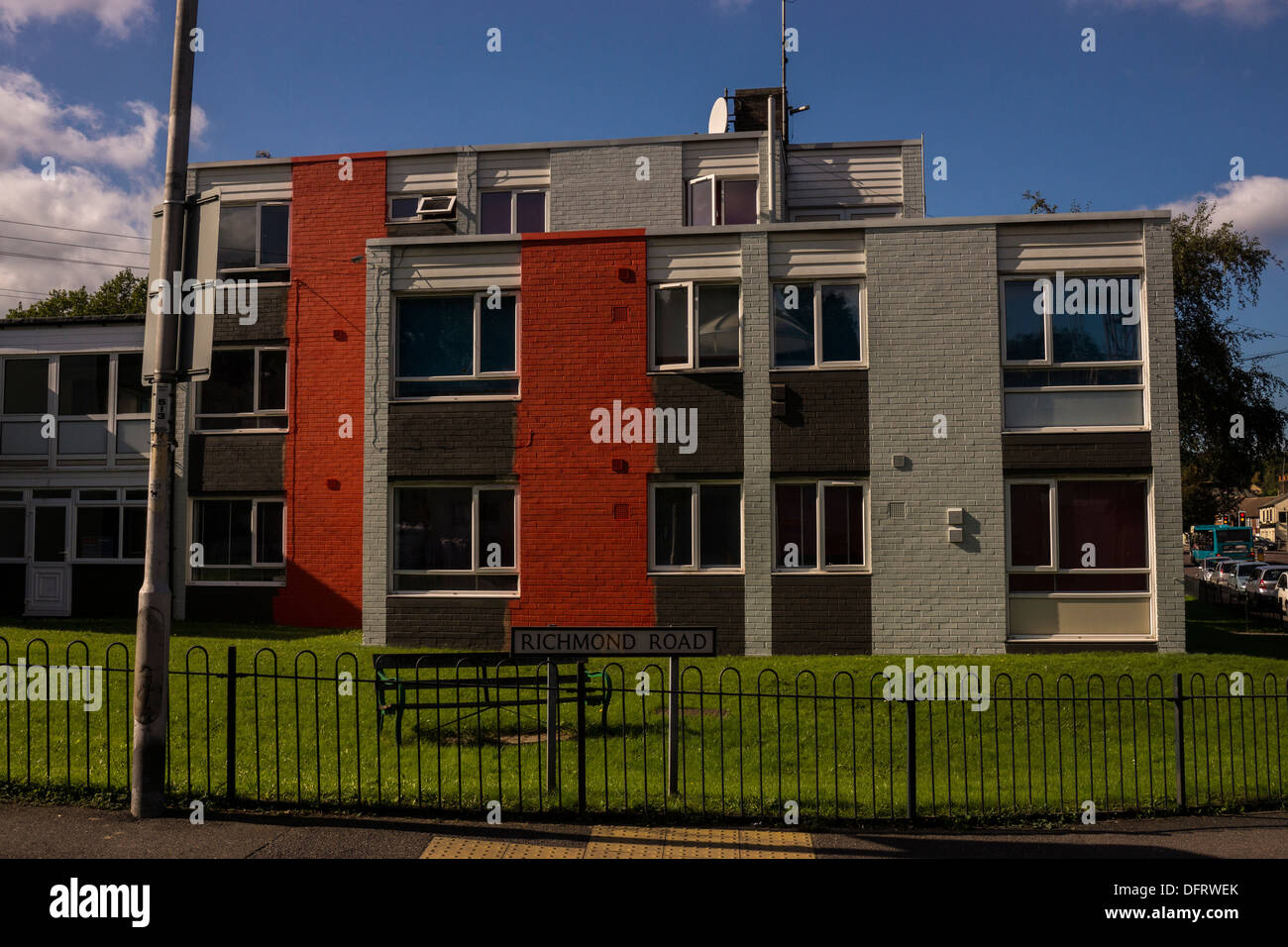 Autunno edificio rosso a strisce marrone panchina erba tagliata Foto Stock
