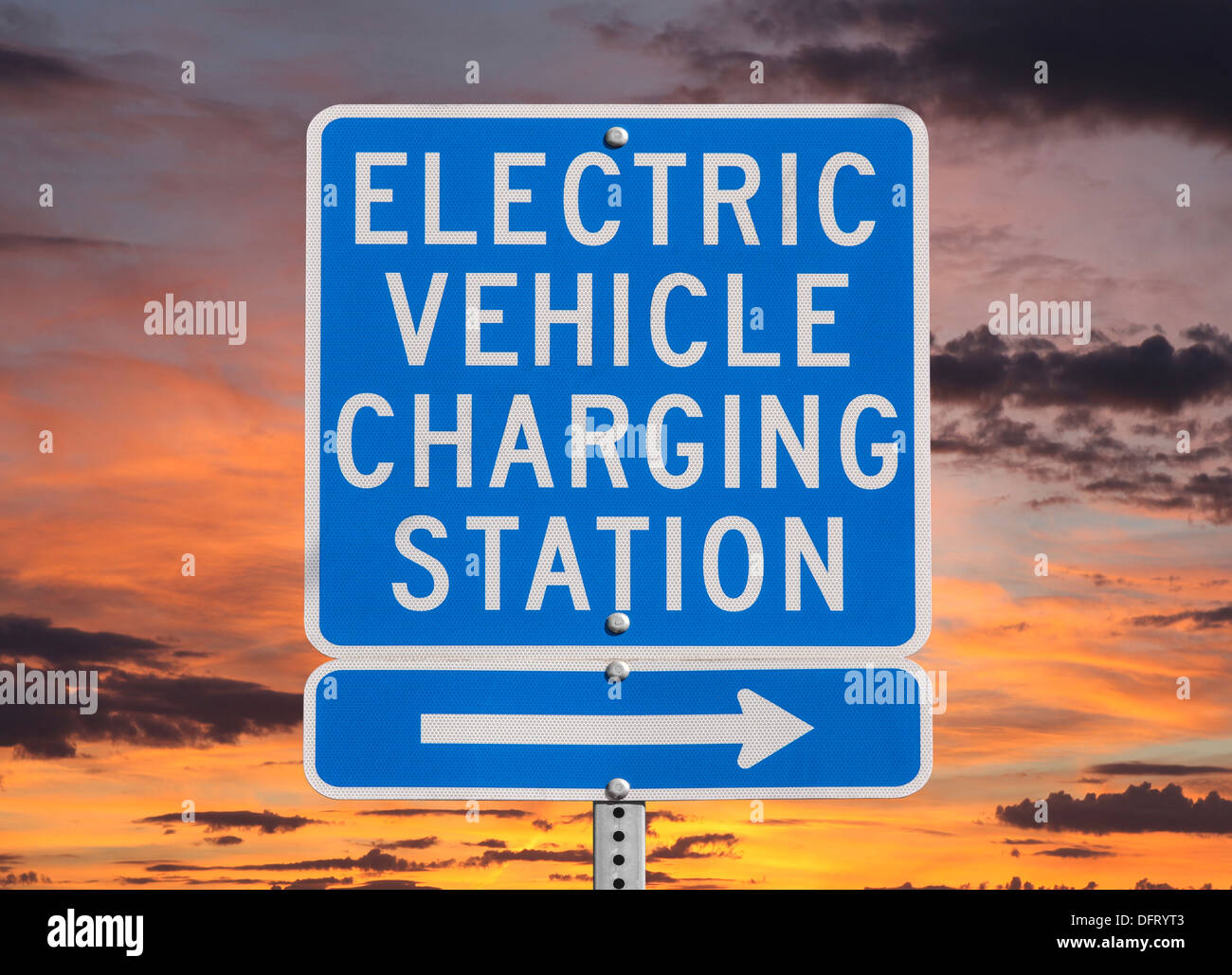 Il veicolo elettrico stazione di carica segno isolato con il cielo al tramonto. Foto Stock
